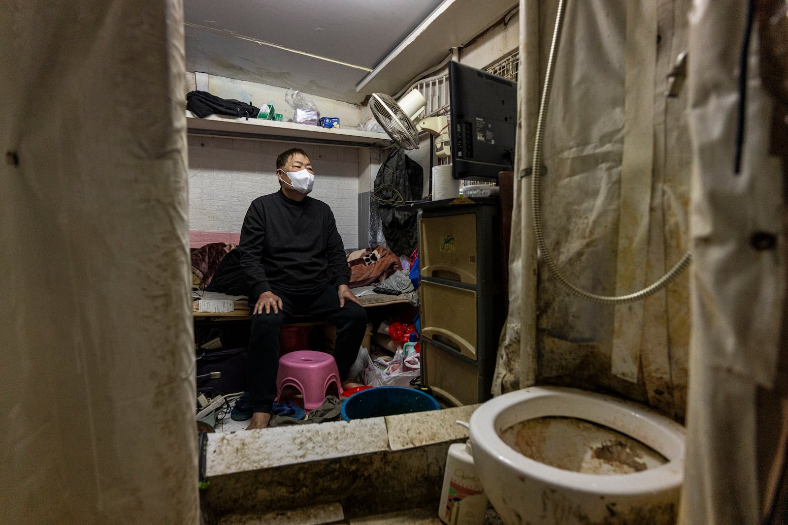 A resident who gave his name as Chiu watches television at his subdivided flat in Sham Shui Po district of Hong Kong, on Feb. 6, 2025. (AP Photo/Chan Long Hei)