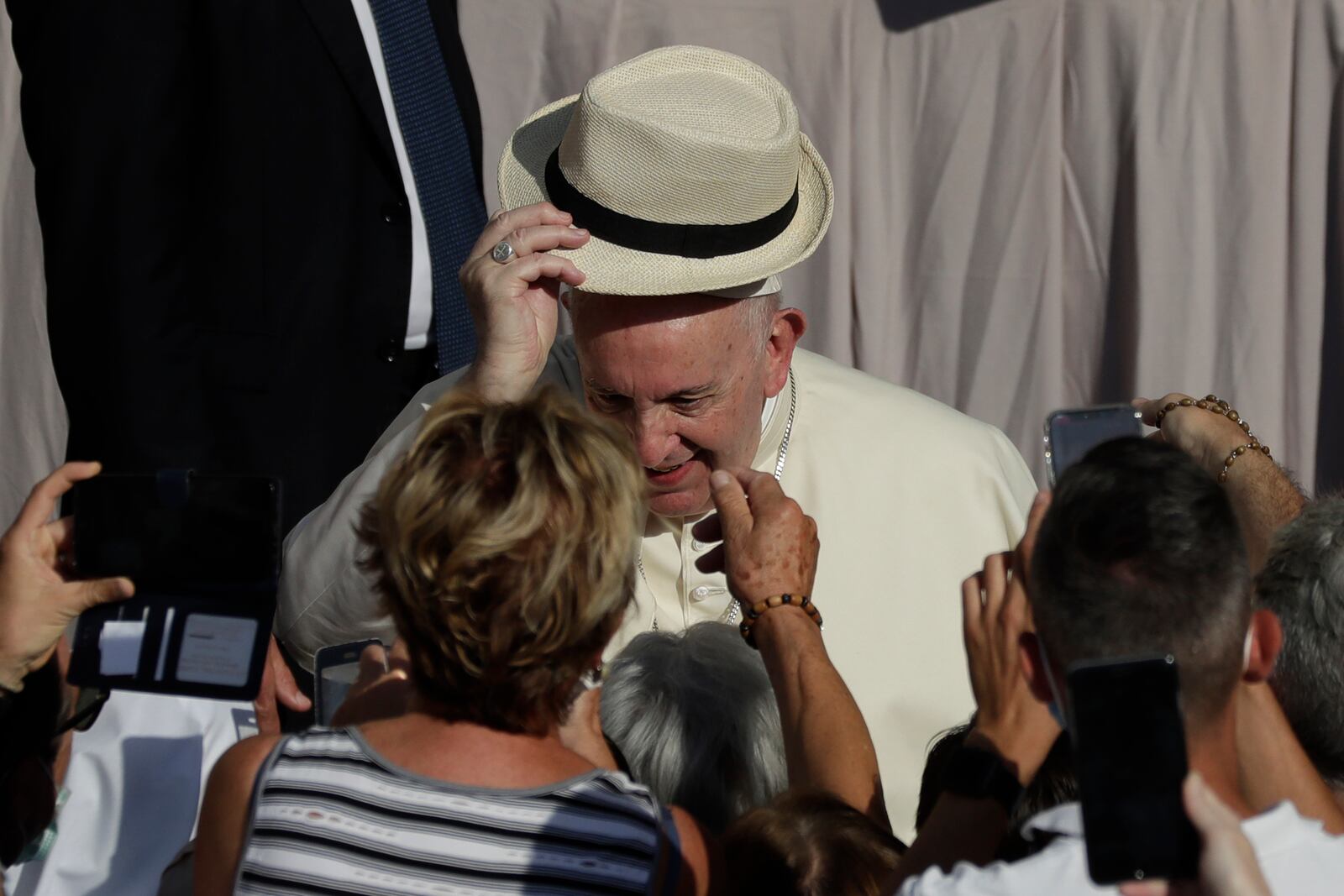 Pope Francis tries on a hat he was presented with as he arrives during his weekly general audience in San Damaso courtyard at the Vatican, Wednesday, Sept. 9, 2020. (AP Photo/Andrew Medichini)