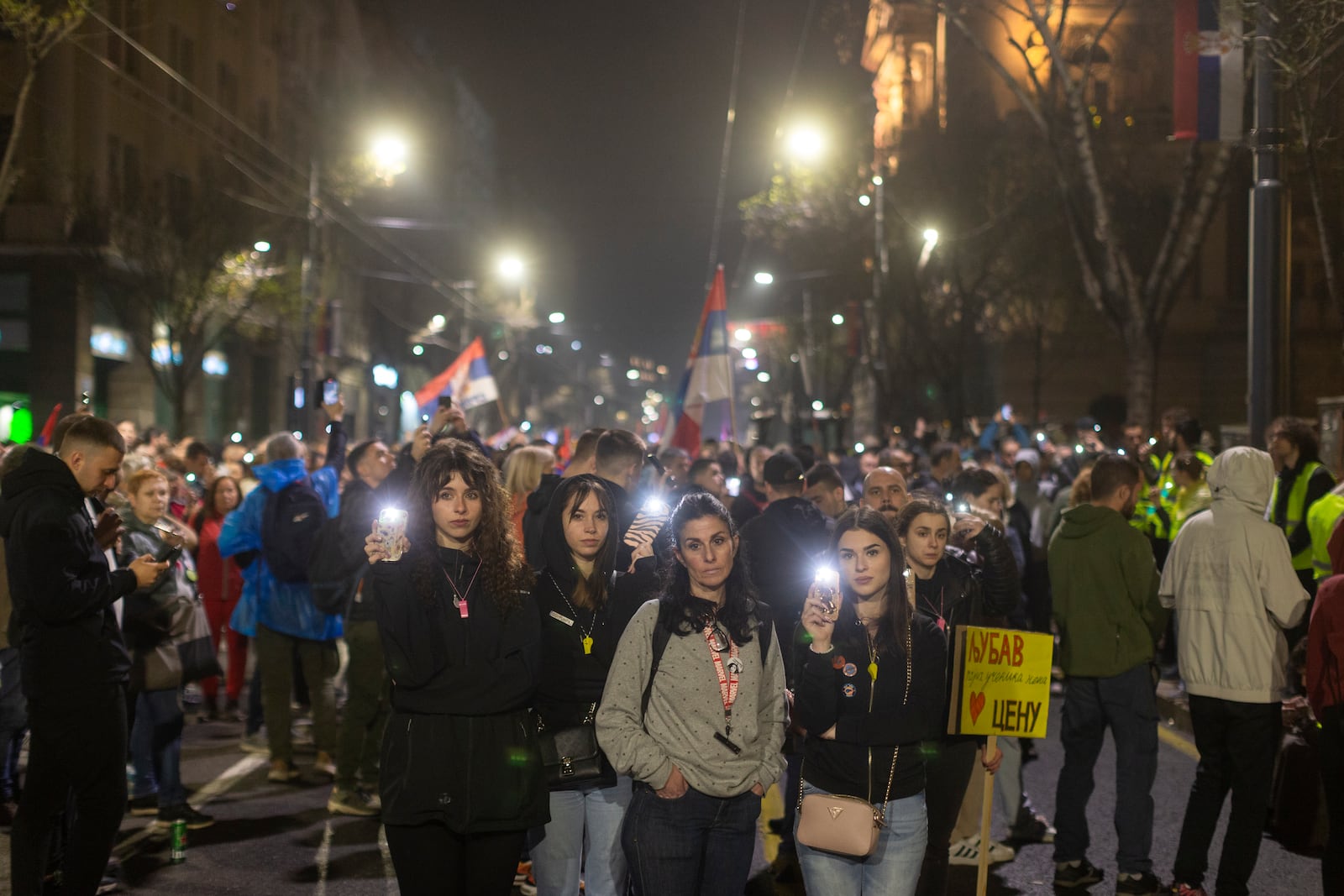 People use the lights on their cell phones as they observe fifteen minutes of silence during a major anti-corruption rally led by university students in Belgrade, Serbia, Saturday, March 15, 2025. (AP Photo/Marko Drobnjakovic)