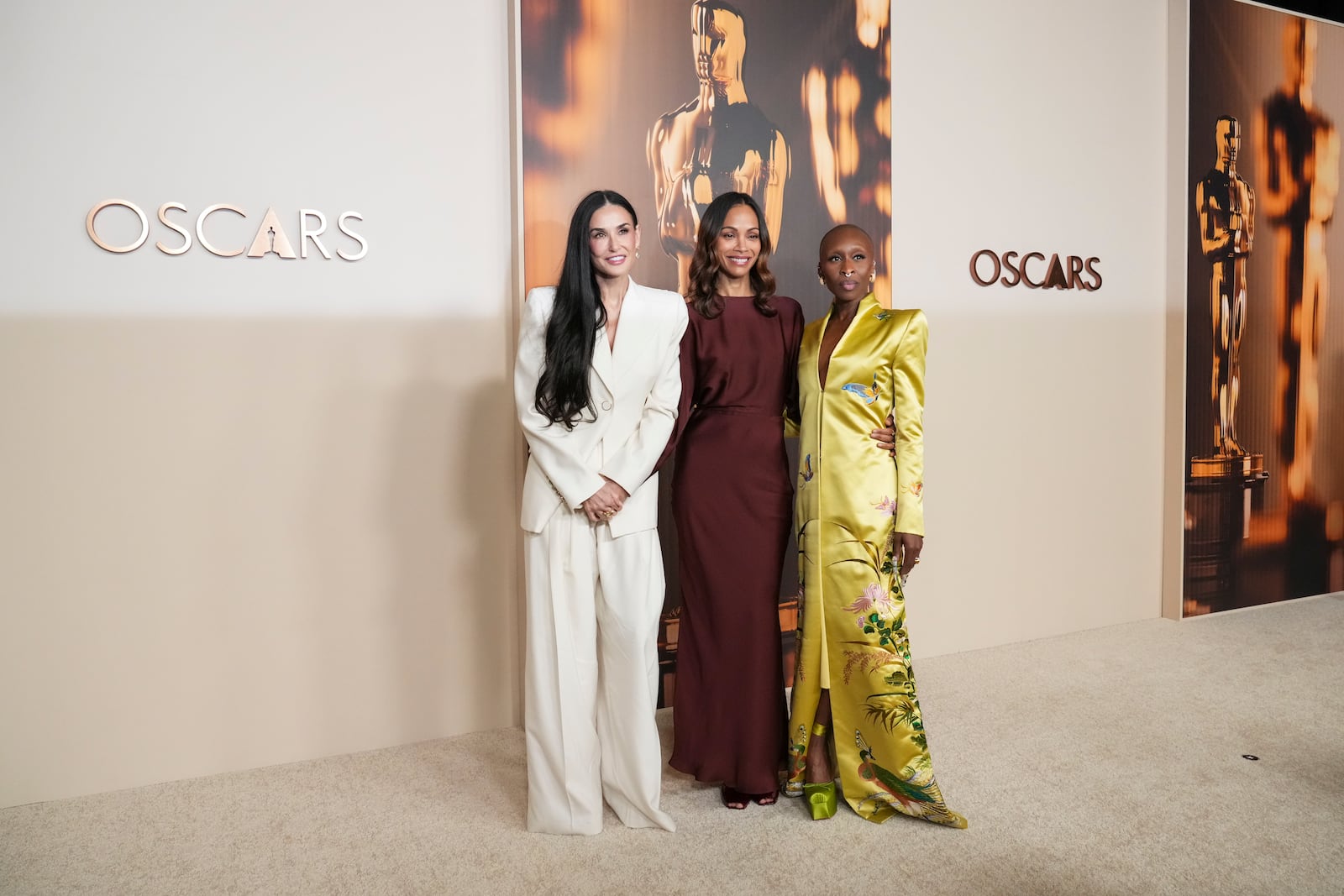 Demi Moore, from left, Zoe Saldana, and Cynthia Erivo arrive at the Oscars Nominees Dinner on Tuesday, Feb. 25, 2025, at the Academy Museum of Motion Pictures in Los Angeles. (Photo by Jordan Strauss/Invision/AP)