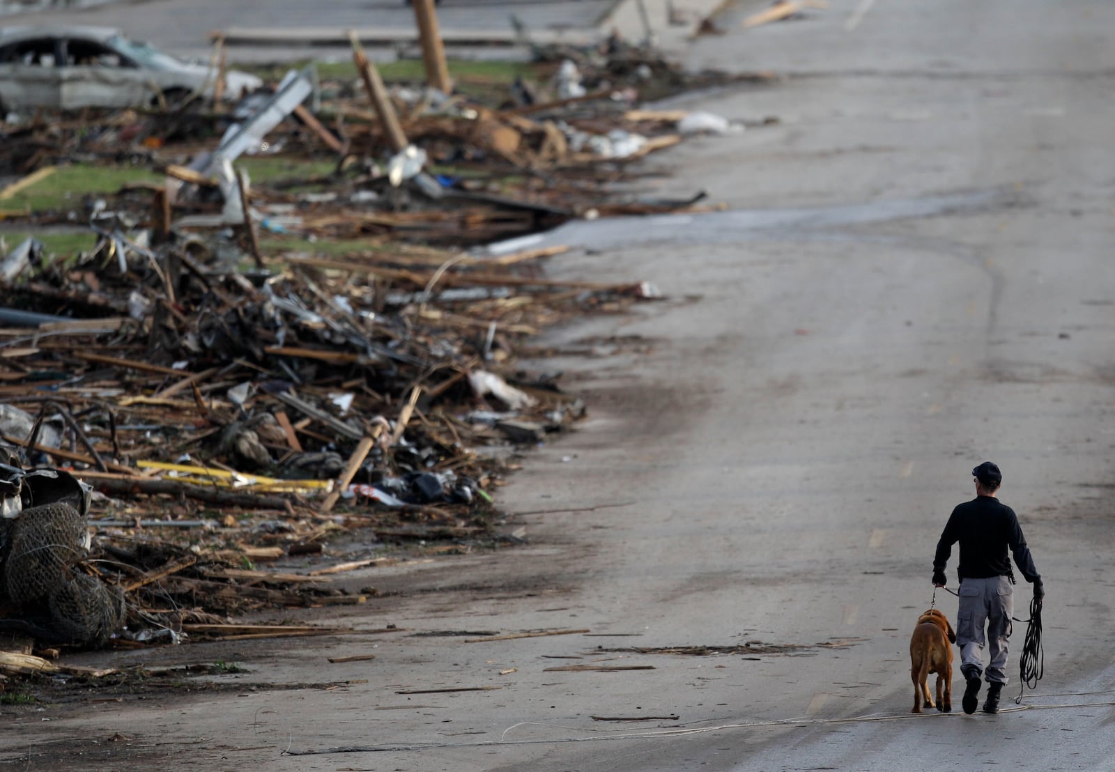 FILE- A rescue worker walks past debris at Joplin High School, which was severely damaged by a tornado in Joplin, Mo., Monday, May 23, 2011. (AP Photo/Charlie Riedel, File)