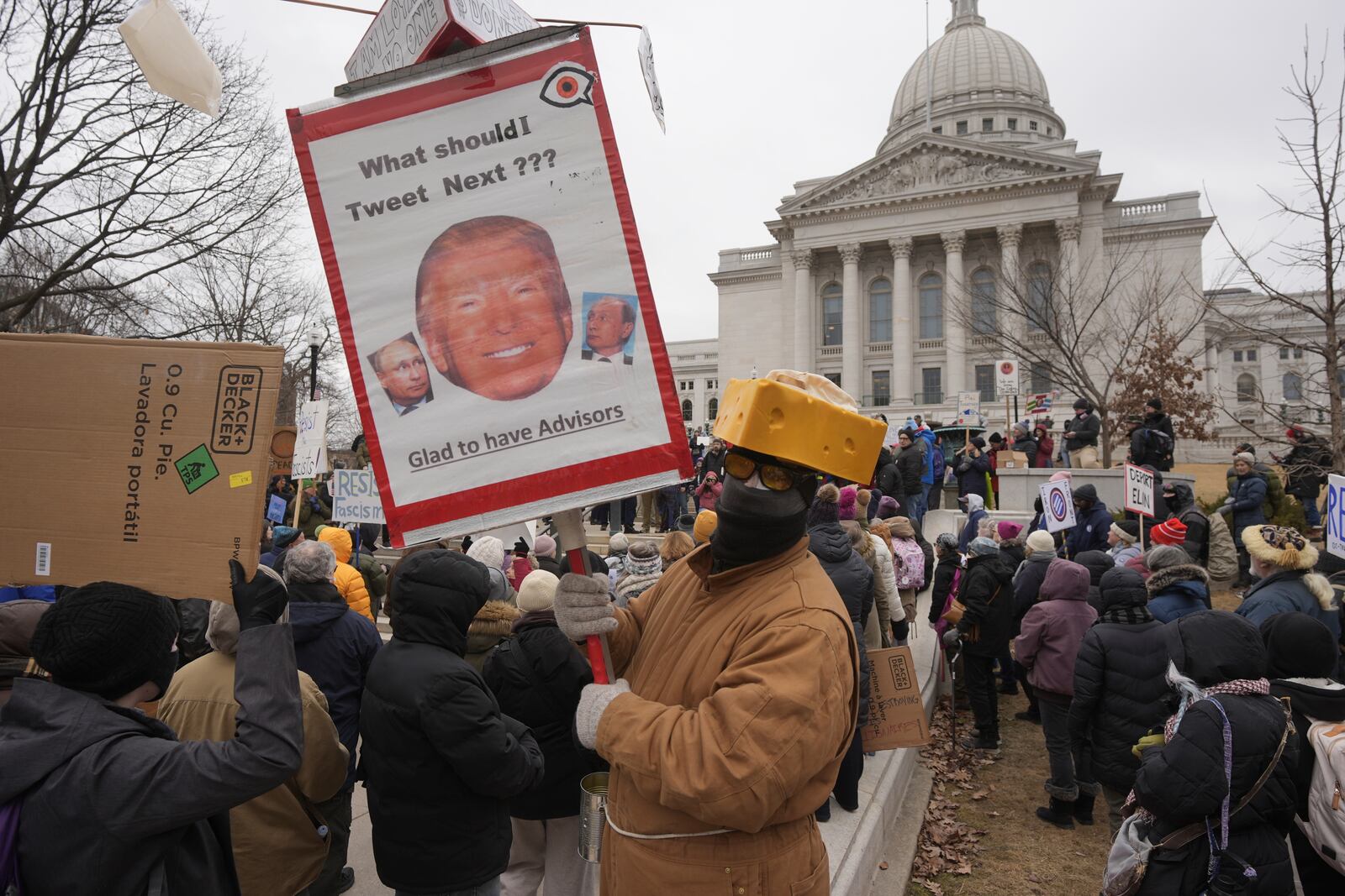 Larry Dinger holds a sign during a protest outside the Wisconsin Capitol Wednesday, Feb. 5, 2025, in Madison, Wis. (AP Photo/Morry Gash)