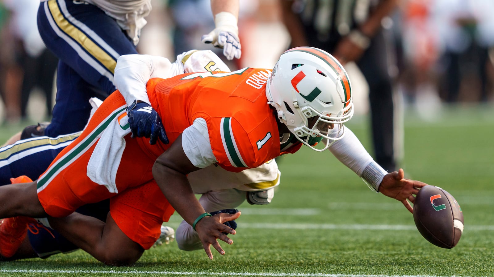 Miami quarterback Cam Ward (1) loses the football while being tackled by Georgia Tech defensive lineman Romello Height, behind, during the second half of an NCAA college football game, Saturday, Nov. 9, 2024, in Atlanta. (AP Photo/Jason Allen)