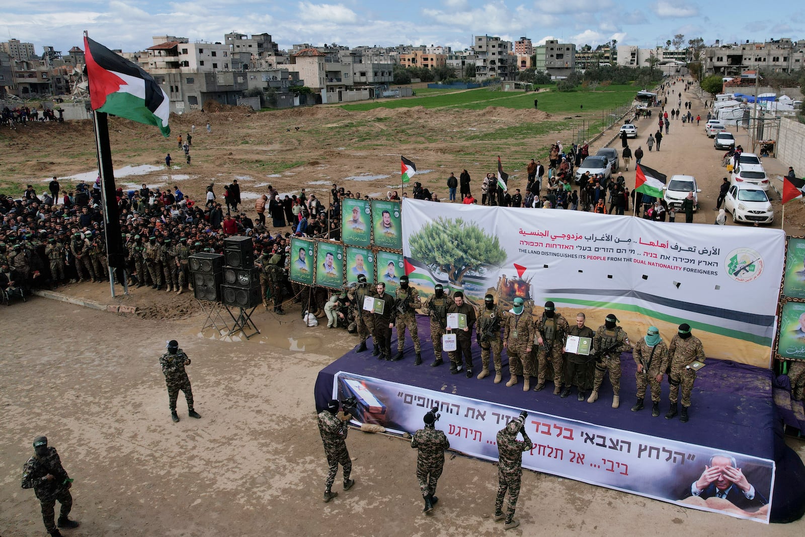 Israeli hostages, from left to right, Eliya Cohen, Omer Shem and Omer Wenkert, are told to show Hamas issued certificates by Hamas fighters before being handed over to the Red Cross in Nuseirat, central Gaza Strip Saturday, Feb. 22, 2025. (AP Photo/Mohamamd Abu Samra)