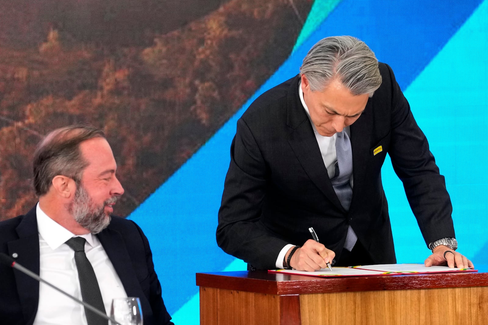 Brazil's Minister of Mines and Energy Alexandre Silveira watches as BHP Chief Executive Officer Mike Henry signs a multi-billion dollar compensation agreement for damages caused by the 2015 collapse of the Mariana dam owned by the mining company Samarco, a joint venture of Vale and BHP, at the Planalto Presidential Palace, in Brasilia, Brazil, Friday, Oct. 25, 2024. (AP Photo/Eraldo Peres)