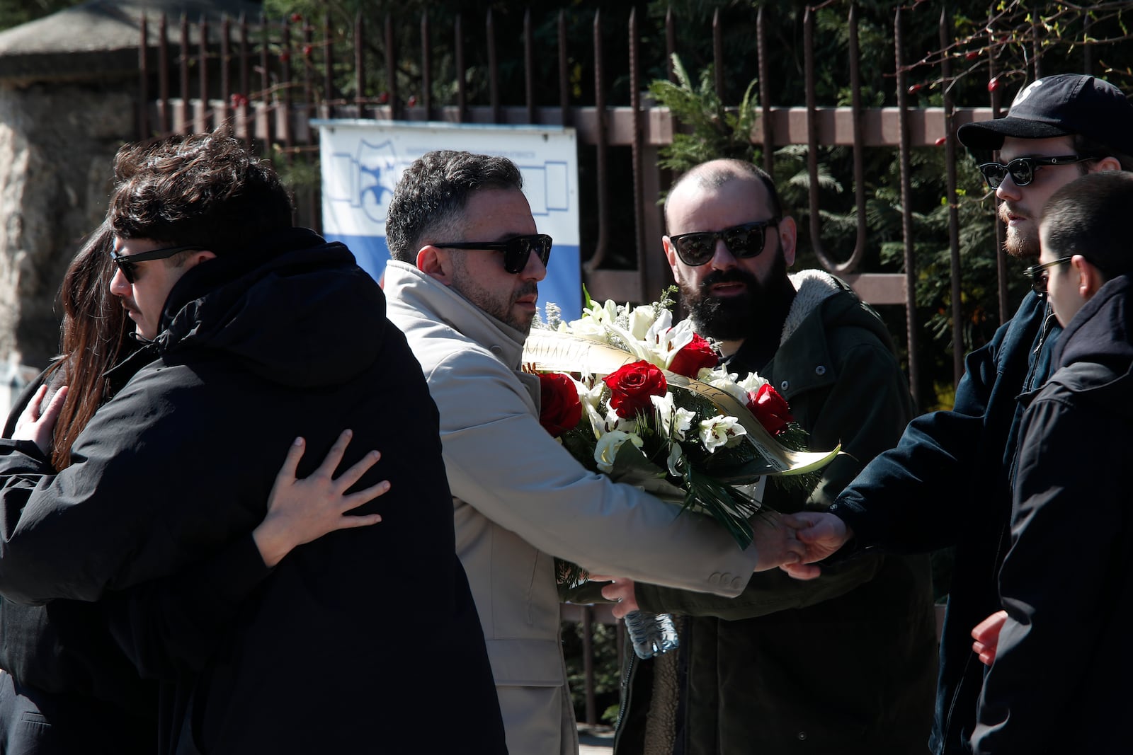 People greet each other as they attend the funeral of Andrej Gjorgieski, one of the lead singers of Macedonian band DNK, a victim of the March 16 nightclub fire in the town of Kocani, at a cemetery in Skopje, North Macedonia, Thursday, March 20, 2025. (AP Photo/Boris Grdanoski)