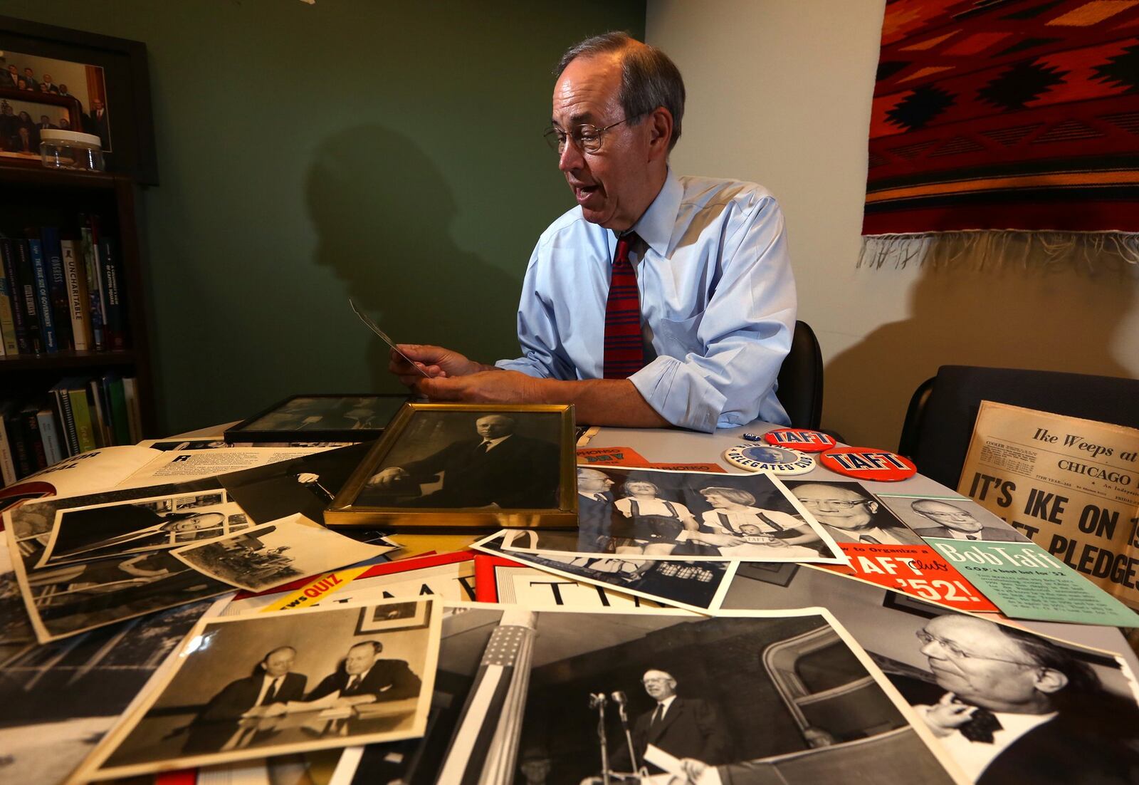 Former Ohio Gov. Bob Taft looks through photographs and memorobilia relating to his grandfather the late Sen. Robert A. Taft who tried three times to become the Republican nominee for president. LISA POWELL / STAFF