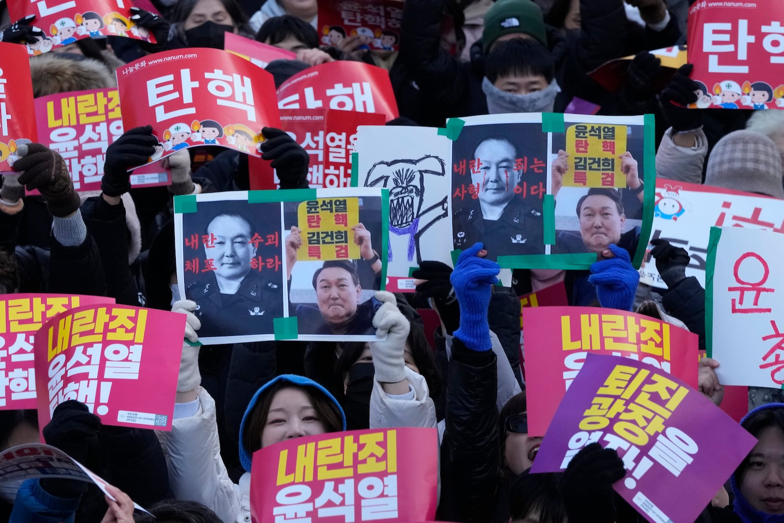 Protesters attend a rally demanding South Korean President Yoon Suk Yeol's impeachment, in front of the National Assembly in Seoul, South Korea, Saturday, Dec. 7, 2024, following the president's short-lived martial law declaration. The signs read, "Impeach Yoon Suk Yeol." (AP Photo/Ahn Young-joon)