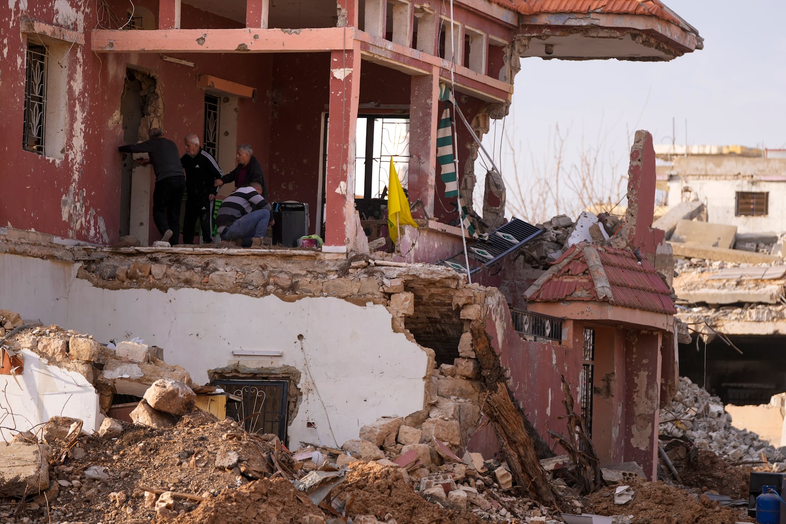 Lebanese citizens check the destruction on their house caused by the Israeli air and ground offensive, in their hometown Khiam, southern Lebanon, Monday, Feb. 17, 2025. (AP Photo/Hassan Ammar)