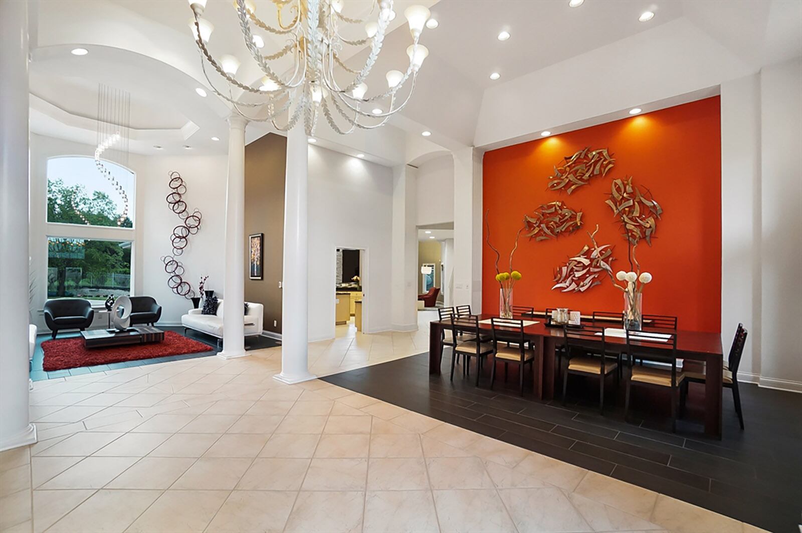 White marble changes into dark wood-grain flooring to accent the formal dining room and living room. The dining room has a tray ceiling while the circular living room has a dorm tray ceiling and arched windows. Fluted woodwork and contrasting accent walls are highlighted by additional lights. CONTRIBUTED PHOTO