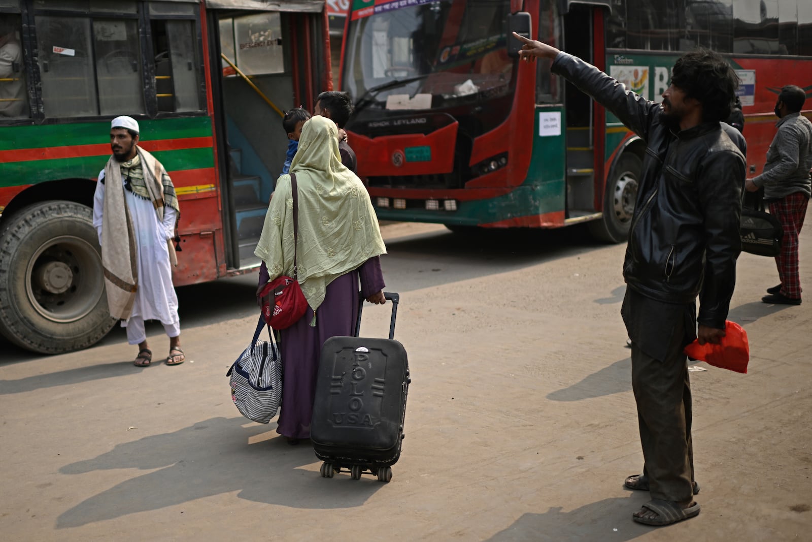 Stranded passengers wait outside a railway station after trains across the country have been canceled as railway workers went on strike for higher pensions and other benefits, in Dhaka, Bangladesh, Tuesday, Jan. 28, 2025. (AP Photo/Mahmud Hossain Opu)