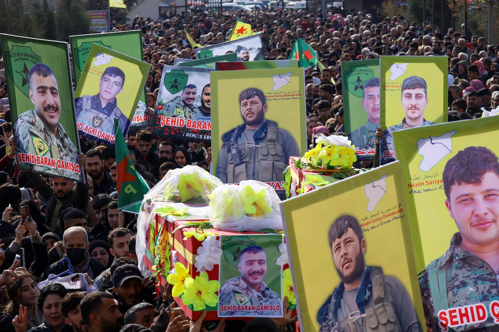 The coffins of two of six Kurdish fighters from the Syrian Democratic Forces (SDF) killed in ongoing clashes with Turkish-backed militias in northern Syria are carried during their funeral in Qamishli, northeastern Syria, Thursday, Dec. 26, 2024. (AP Photo/Hogir El Abdo)