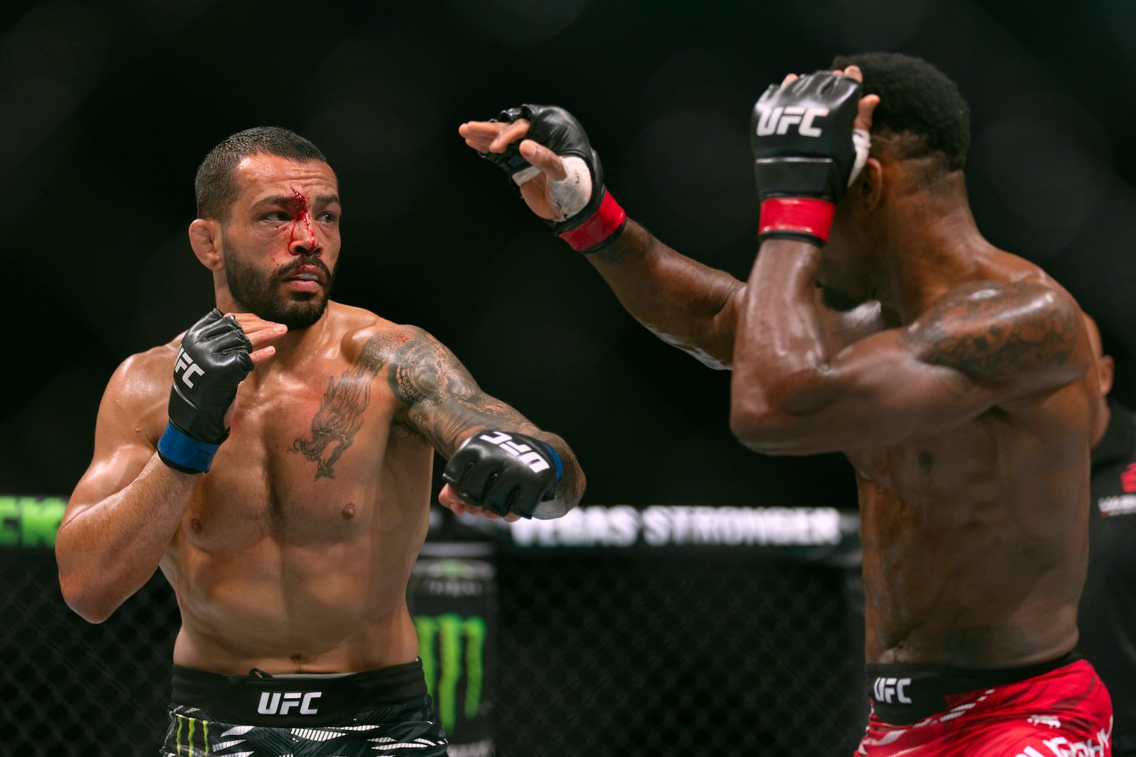 Lerone Murphy, right, fights with Dan Ige during a featherweight mixed martial arts bout at UFC Fight Night on Saturday, Oct. 26, 2024, in Abu Dhabi, United Arab Emirates. (AP Photo/Altaf Qadri)