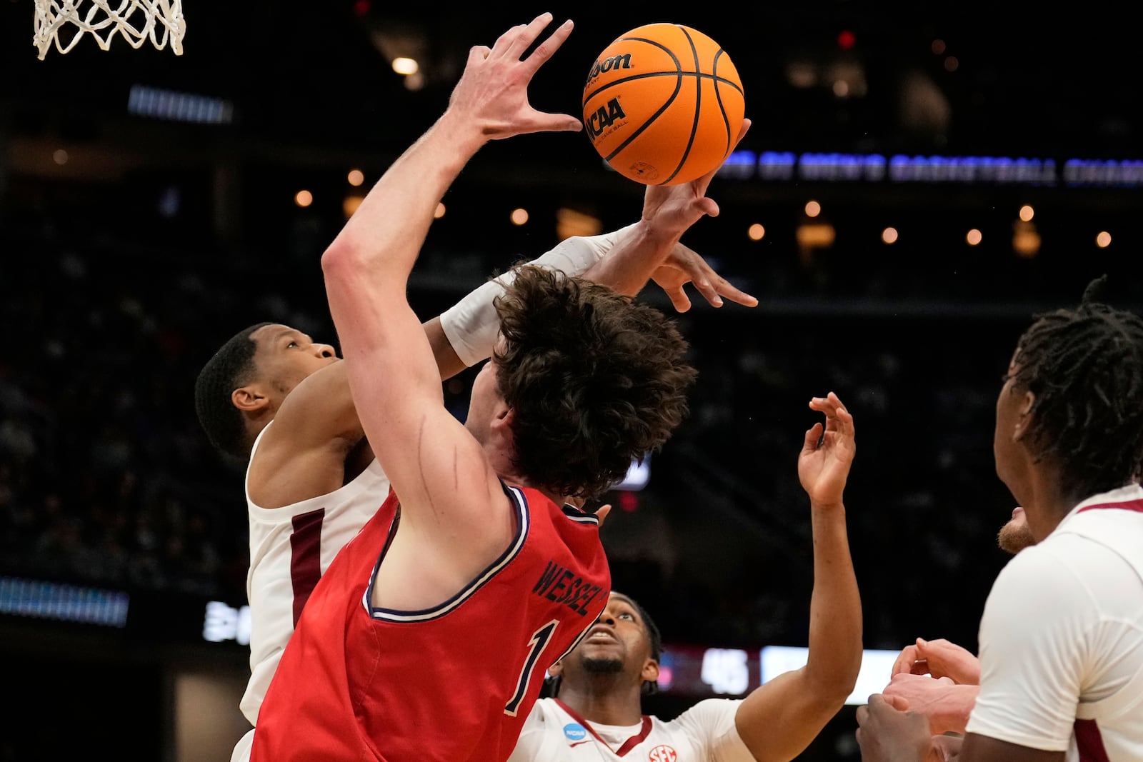 Alabama guard Chris Youngblood, left, knocks the ball away from Saint Mary's center Harry Wessels (1) in front of teammate Mouhamed Dioubate in the second half in the second round of the NCAA college basketball tournament, Sunday, March 23, 2025, in Cleveland. (AP Photo/Sue Ogrocki)