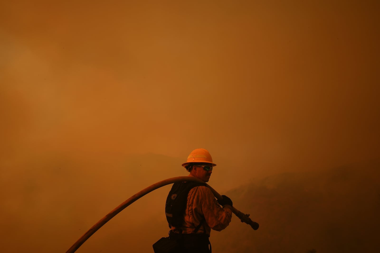 FILE - A firefighter monitors the advance of the Palisades Fire in Mandeville Canyon on Jan. 11, 2025, in Los Angeles. (AP Photo/Eric Thayer, File)