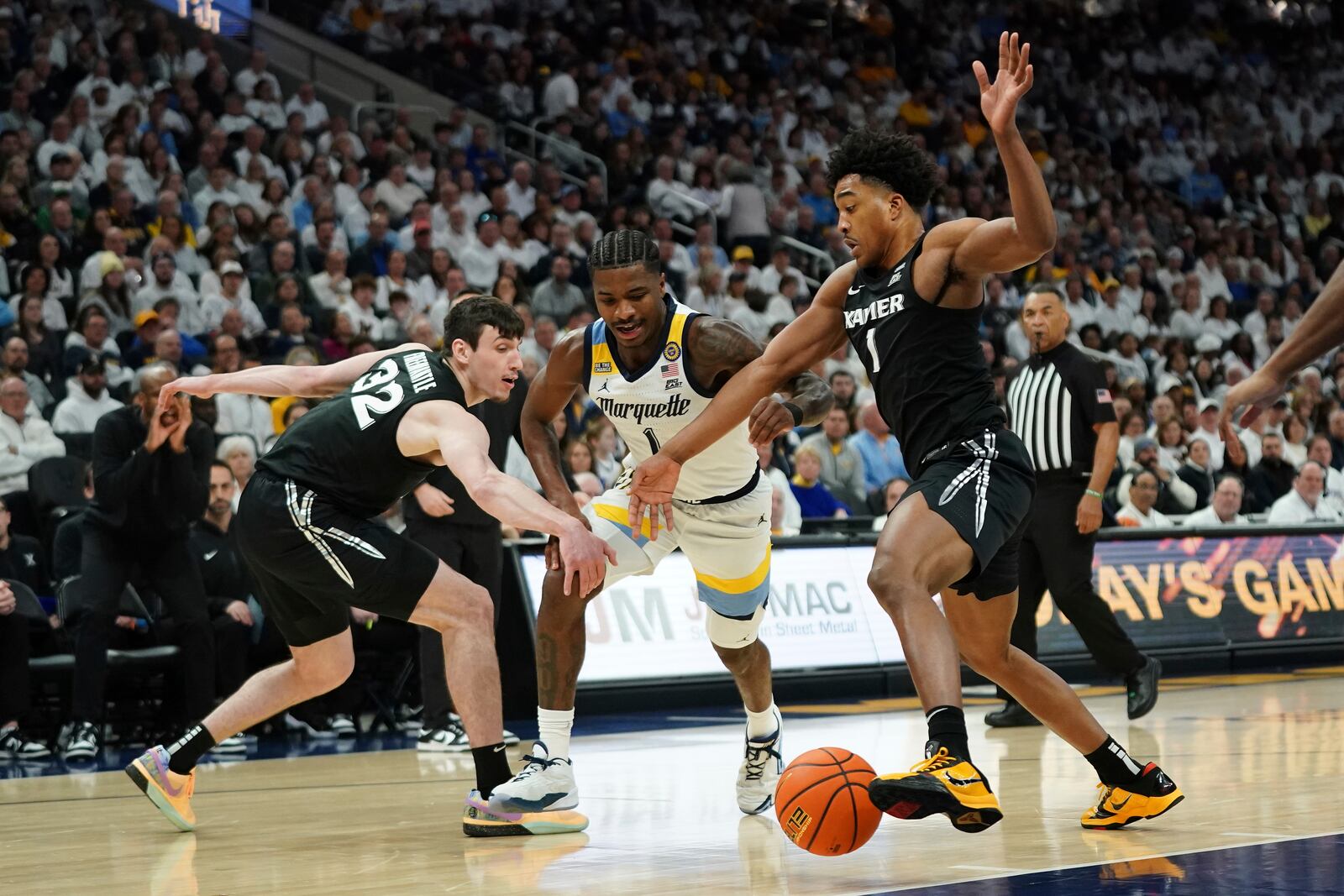 Marquette's Kam Jones, center, loses control of the ball between Xavier's Marcus Foster, right, and Zach Freemantle, left, during the first half of an NCAA college basketball game Saturday, Jan. 18, 2025, in Milwaukee. (AP Photo/Aaron Gash)