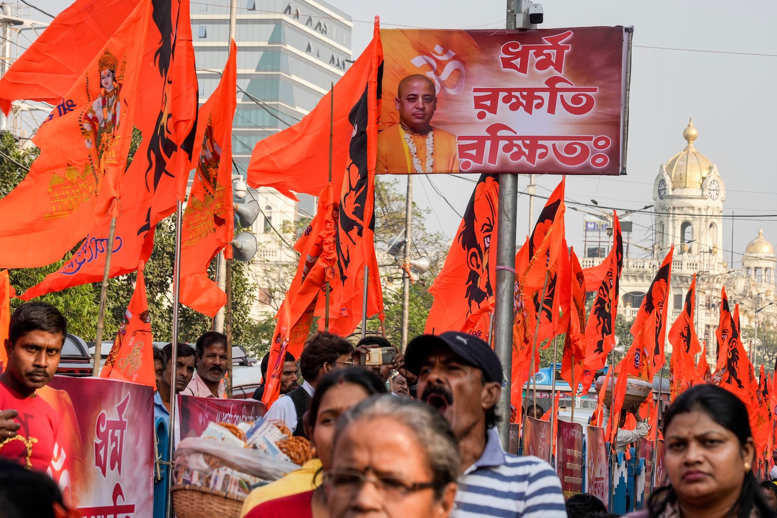 A poster of arrested prominent Hindu leader Krishna Das Prabhu displayed on a lamp post amidst rows of Hindu religious flags during a protest rally condemning the recent arrest of Das and the alleged attacks on Hindus in Bangladesh, in Kolkata, India, Thursday, Dec. 5, 2024. (AP Photo/Bikas Das)