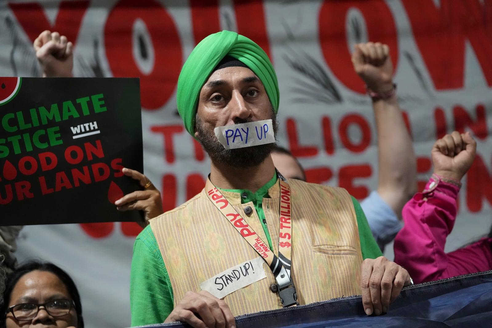 Activists participate in a demonstration for climate finance at the COP29 U.N. Climate Summit, Friday, Nov. 22, 2024, in Baku, Azerbaijan. (AP Photo/Sergei Grits)