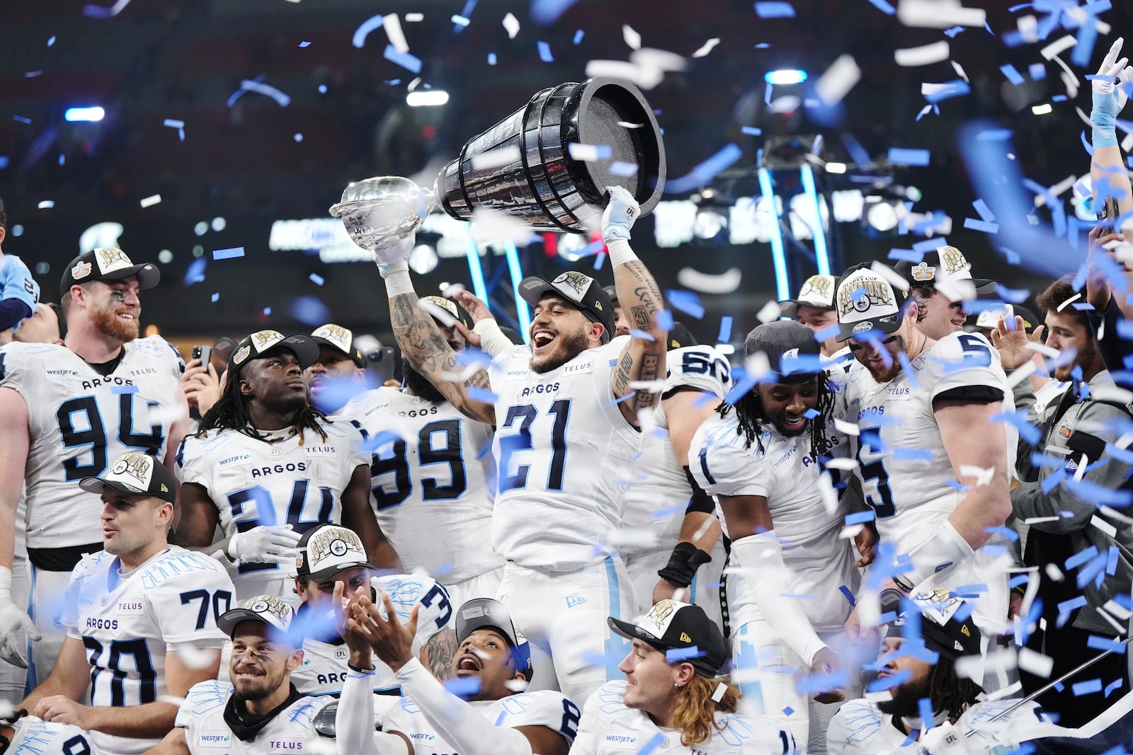 Toronto Argonauts' Daniel Adeboboye (21) lifts the Grey Cup after defeating the Winnipeg Blue Bombers in a CFL football game at the 111th Grey Cup in Vancouver, British Columbia, Sunday, Nov. 17, 2024. (Darryl Dyck/The Canadian Press via AP)