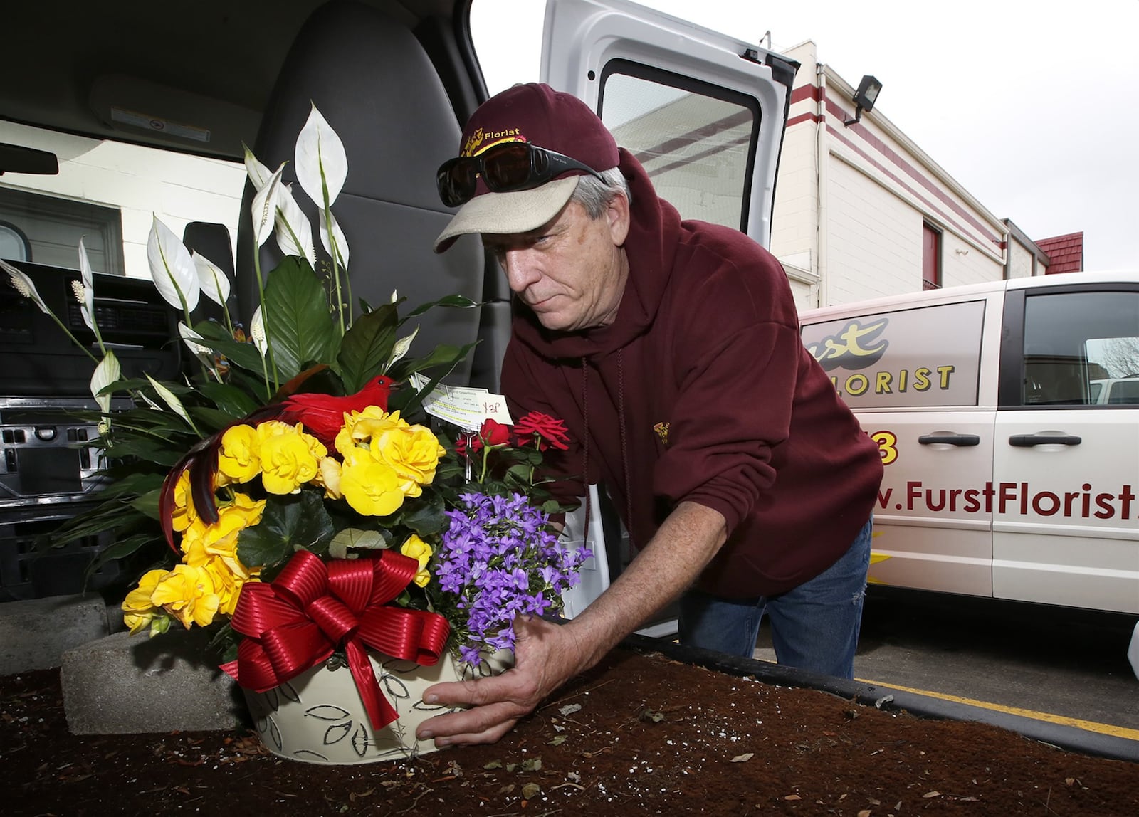 Furst Florist delivery driver John Daly loads his van on Thursday for a trip to Centerville and Springboro. Local flow shops have seen an increase in business as the price of gasoline as gone down.