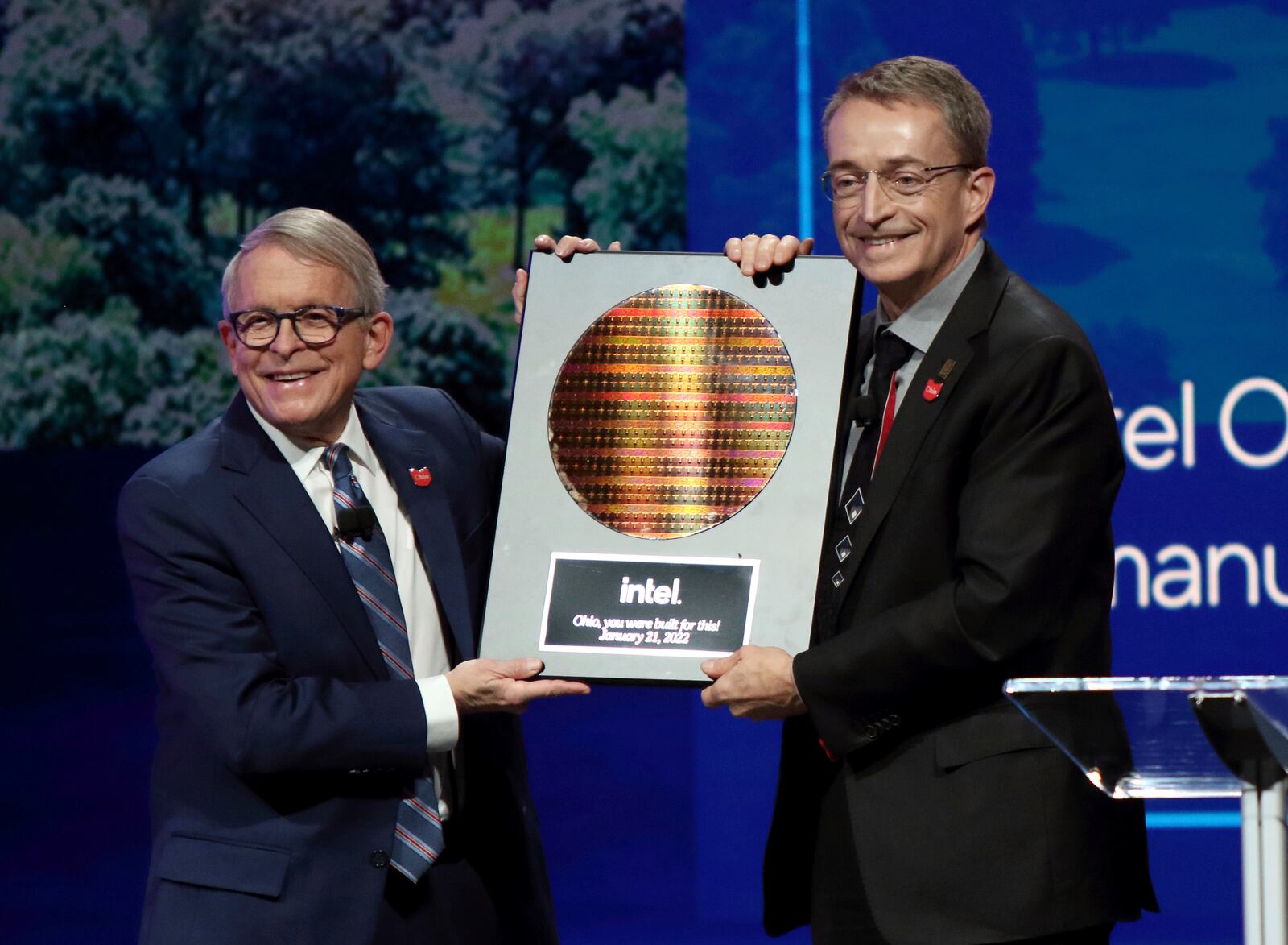 FILE - Intel CEO Patrick Gelsinger, right, presents Ohio Gov. Mike DeWine with a silicon wafer during on Jan. 21, 2022 in Newark, Ohio, where Intel announced it will invest $20 billion to build two computer chip factories on a 1,000-acre site in Licking County, Ohio, just east of Columbus. Intel said Thursday it will invest $50 million in Ohio higher education initiatives targeting the semiconductor industry, and partner with the U.S. National Science Foundation which is providing an additional $50 million for research grants nationally.  (AP Photo/Paul Vernon, File)