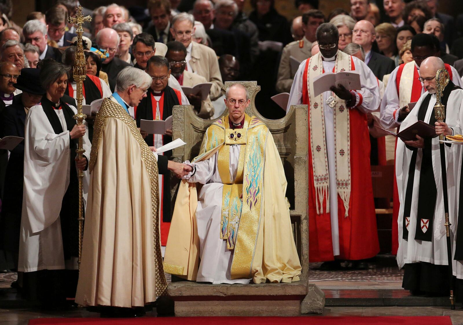 FILE - The Most Reverend Justin Welby sits in the Chair of St Augistine as the Dean of Canterbury Robert Willis takes him by the hand during his enthronement service to become Archbishop of Canterbury at Canterbury Cathedral in Canterbury, England, Thursday, March 21, 2013. (Gareth Fuller, Pool Photo via AP, File)