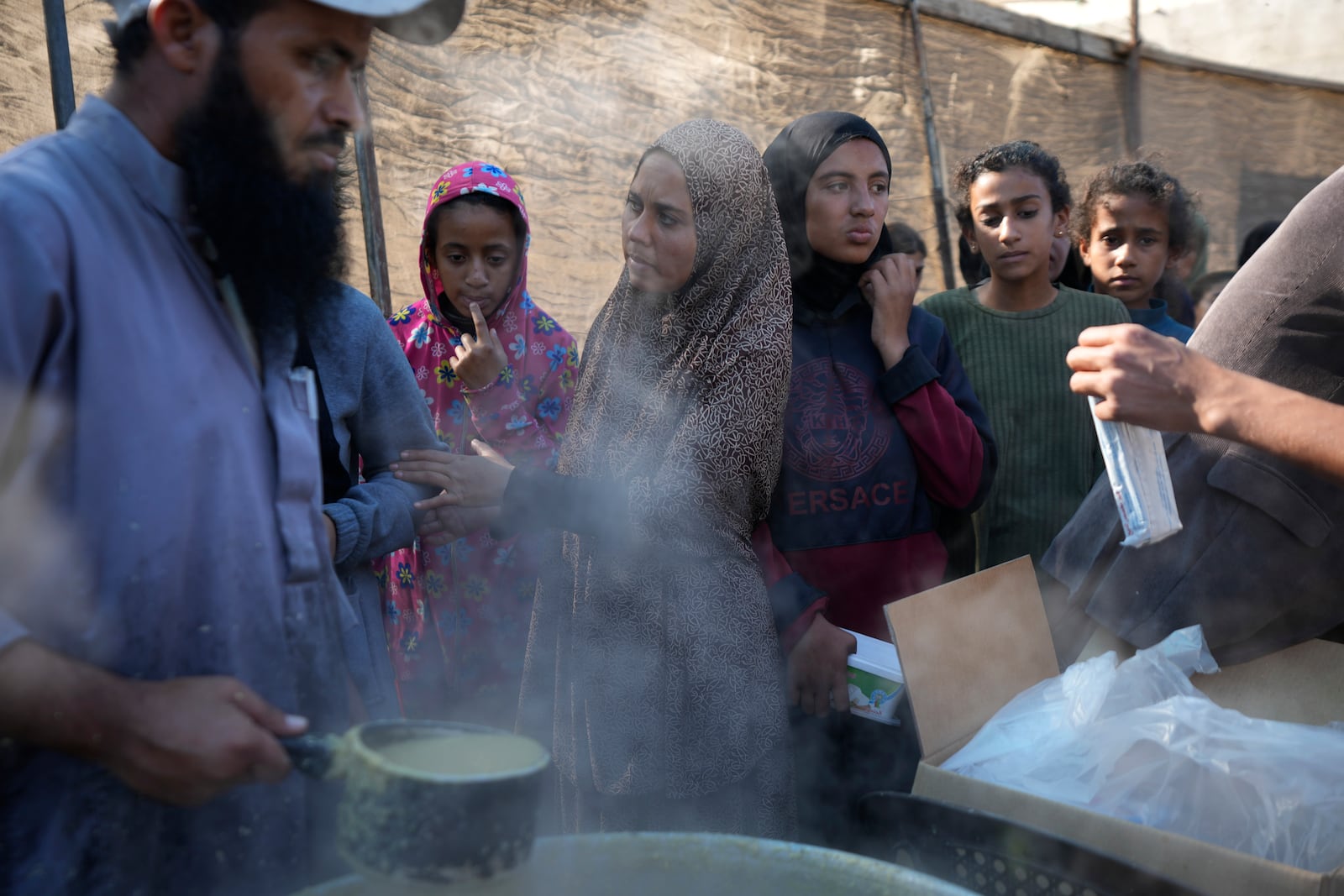 Palestinians queue for food in Deir al-Balah, Gaza Strip, Monday, Nov. 18, 2024. (AP Photo/Abdel Kareem Hana)