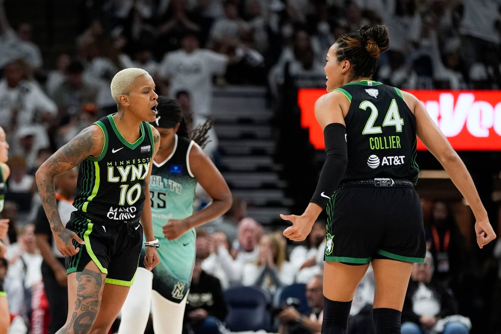 Minnesota Lynx guard Courtney Williams (10) celebrates with forward Napheesa Collier (24) after scoring a basket against the New York Liberty during the first half of Game 4 of a WNBA basketball final playoff series, Friday, Oct. 18, 2024, in Minneapolis. (AP Photo/Abbie Parr)