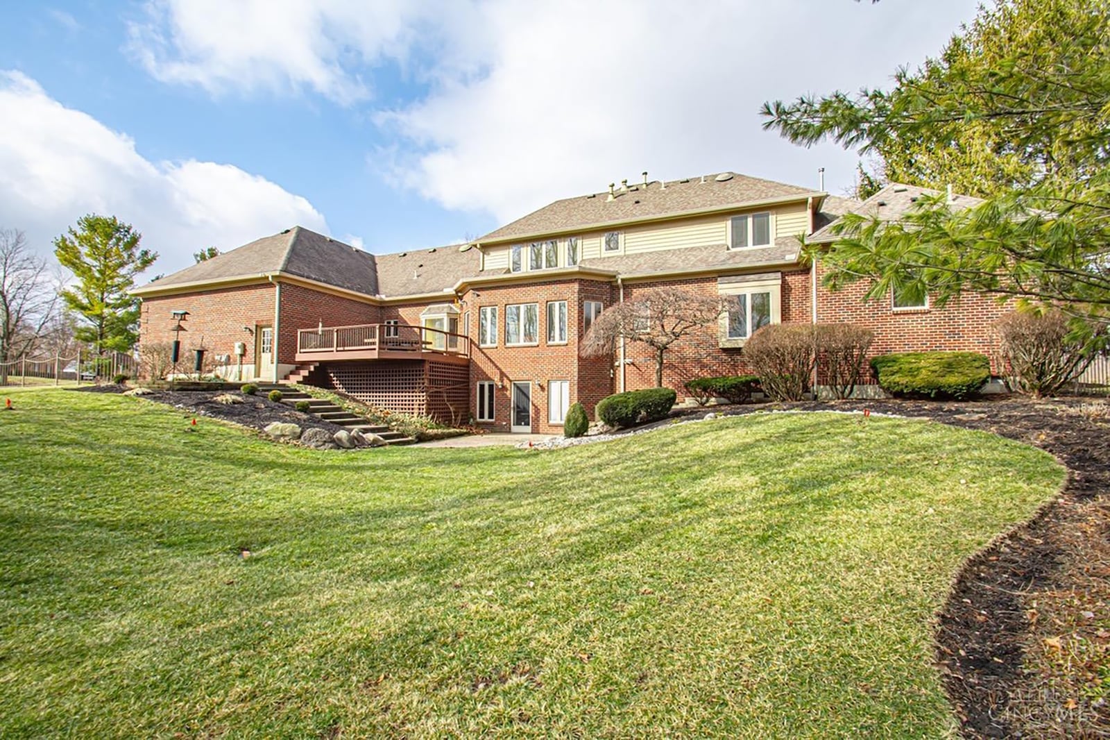 The rear of the home has a wood deck off the family room, a paver patio and an additional concrete patio off the basement level. Part of the two acre lot has a metal fence.