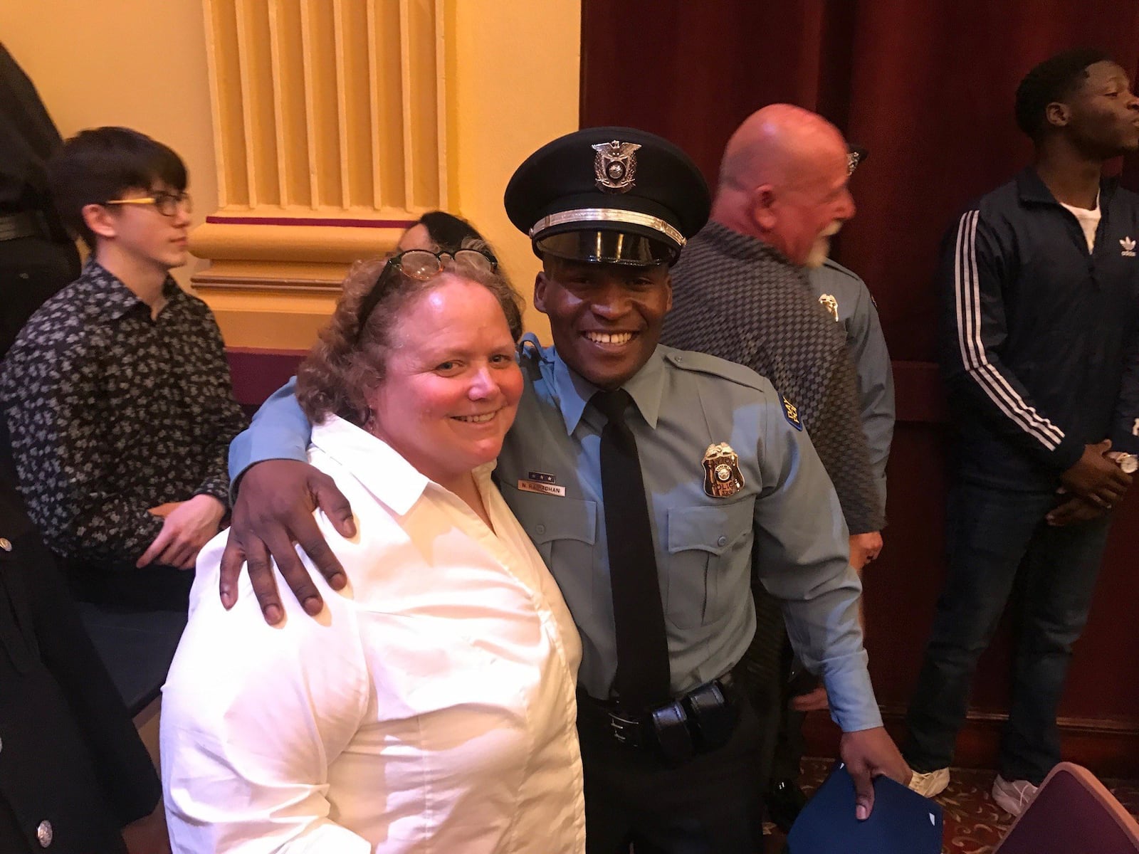 Police Officer Ndayisaba Ramadhan with former Belmont soccer coach Julie Raiff at the 108th Recruit Class Graduation Ceremony Friday night at Stivers High School. Tom Archdeacon/STAFF