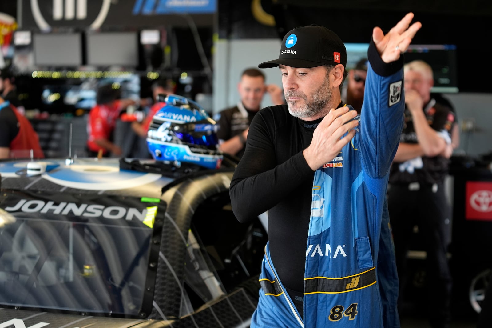 Jimmie Johnson puts on his firesuit before a practice for the NASCAR Daytona 500 auto race Saturday, Feb. 15, 2025, at Daytona International Speedway in Daytona Beach, Fla. (AP Photo/Chris O'Meara)