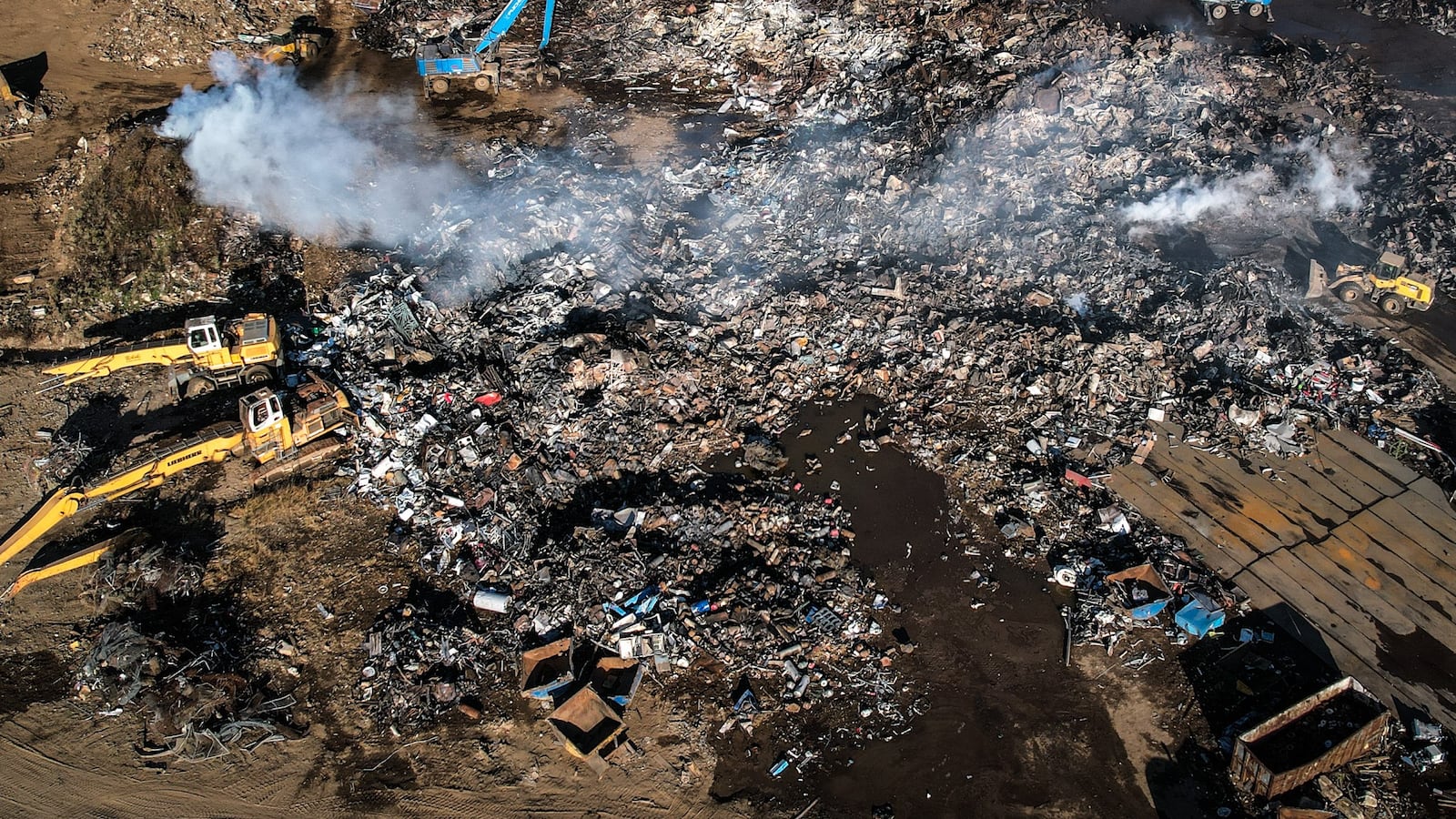 Smoke is still billowing at the Cohen Recycling Center in West Carrollton Monday morning, Oct. 10, 2022. The fire started around noon Sunday. Fire crews left the property on Farmersville West Carrollton Road around 9:30 a.m. Monday while large equipment continued to move the smoldering debris around the scrap yard. JIM NOELKER/STAFF