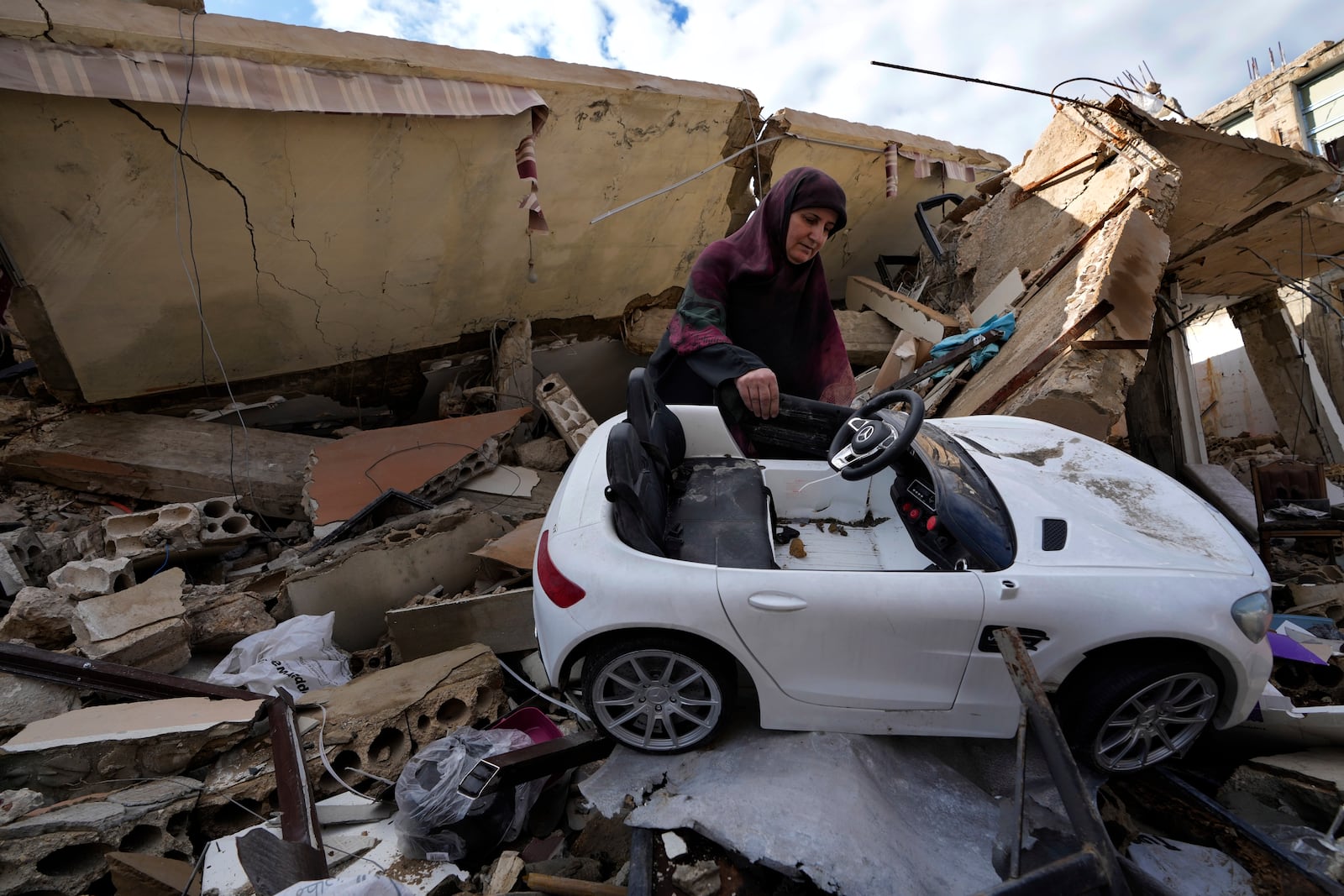 Mariam Kourani, 56, removes a toy car from the rubble on her destroyed house after she returned with her family to Hanouiyeh village, southern Lebanon, Thursday, Nov. 28, 2024 following a ceasefire between Israel and Hezbollah that went into effect on Wednesday. (AP Photo/Hussein Malla)