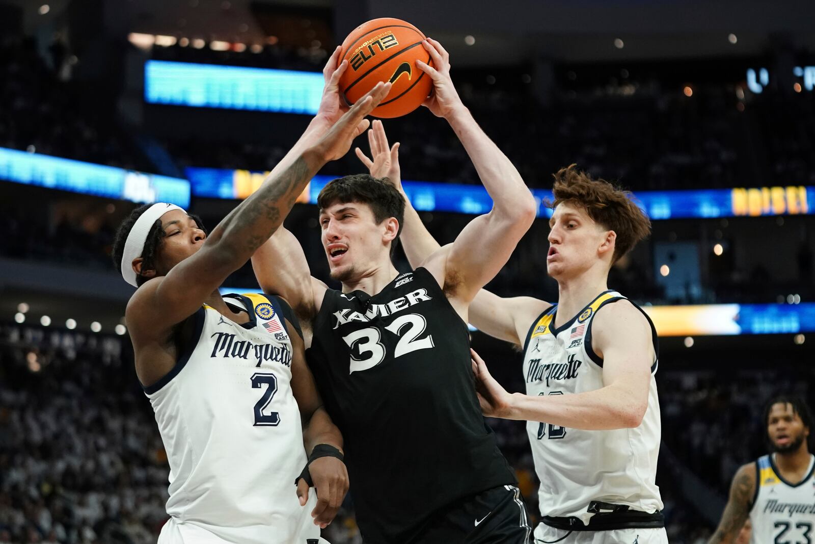 Xavier's Zach Freemantle (32) drives between Marquette's Chase Ross (2) and Ben Gold during the second half of an NCAA college basketball game Saturday, Jan. 18, 2025, in Milwaukee. (AP Photo/Aaron Gash)