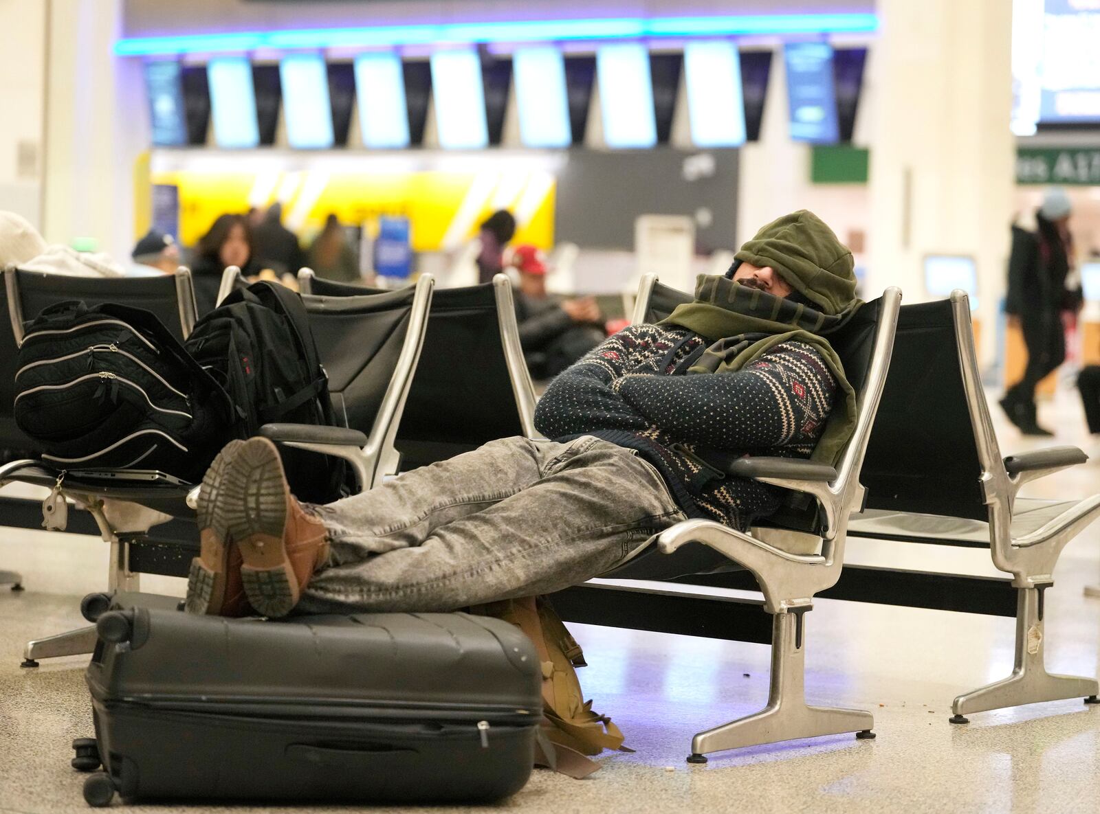 Thor Khalji rests in Terminal A at George Bush Intercontinental Airport Wednesday, Jan. 22, 2025, in Houston. He said his morning flight was delayed until this afternoon. Both Houston airports reopened Wednesday after being closed on Tuesday due to the winter storm. (Melissa Phillip/Houston Chronicle via AP)