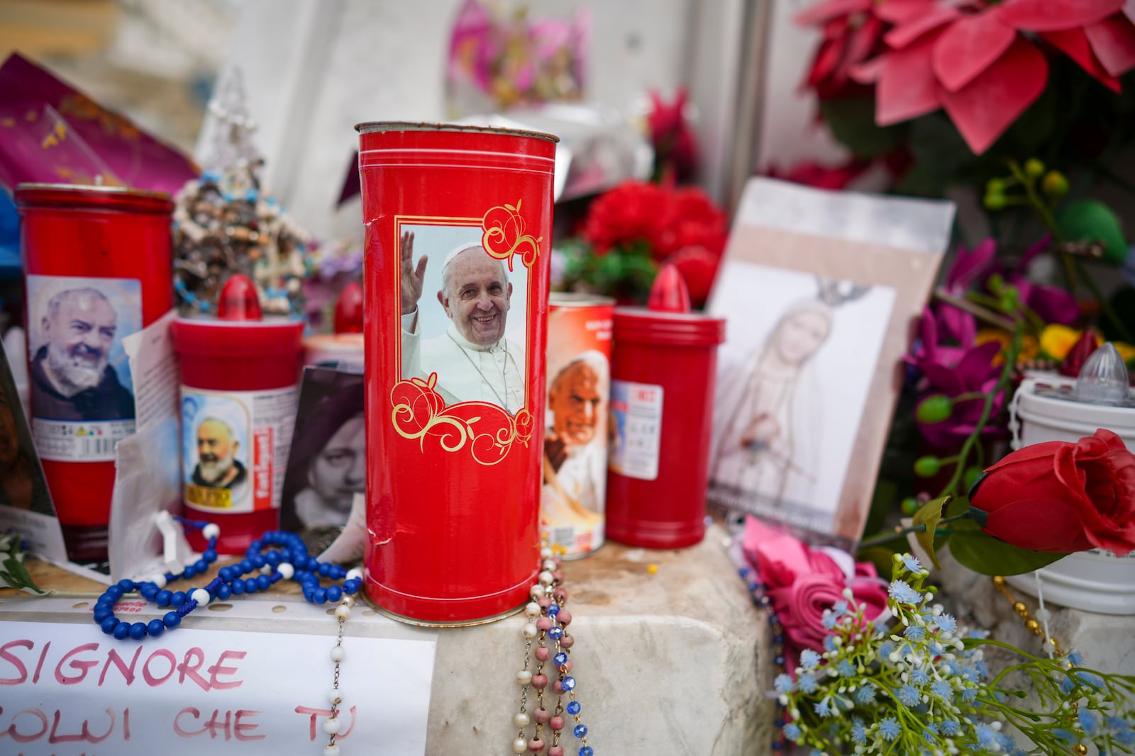 Candles and flowers are left for Pope Francis in front of the Agostino Gemelli Polyclinic, in Rome, Saturday, March 8, 2025, where the Pontiff is hospitalized since Feb. 14. (AP Photo/Andrew Medichini)