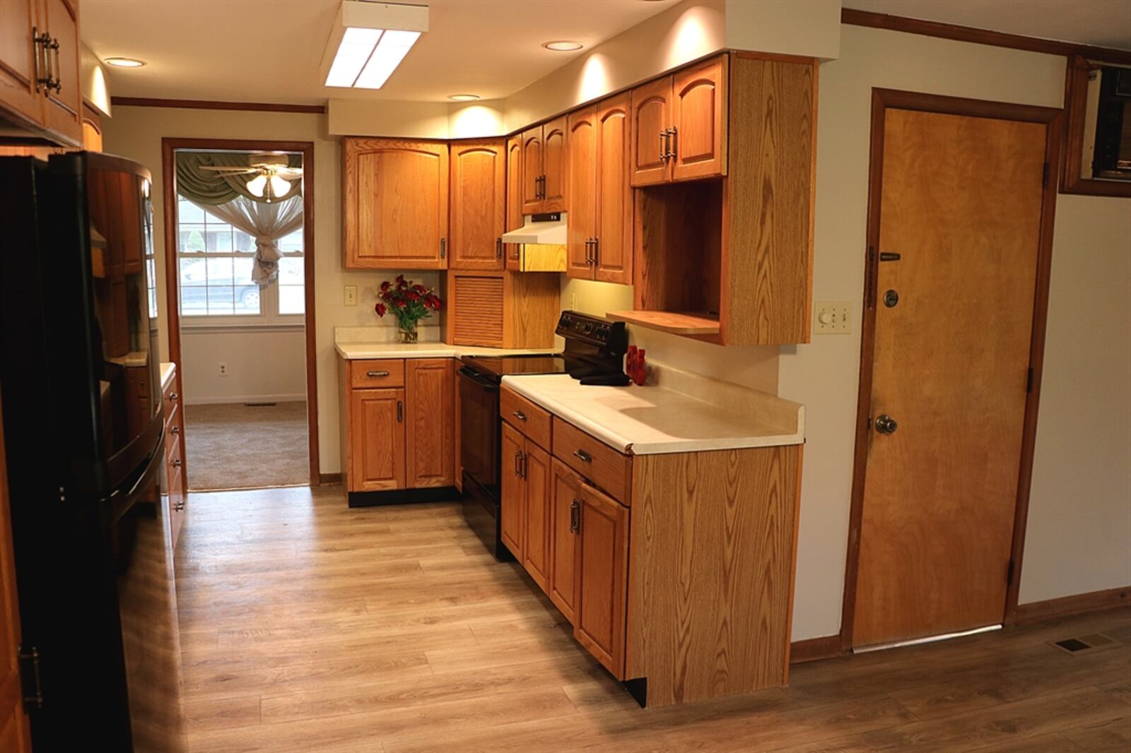 Oak cabinetry fills two walls of the kitchen, which includes an appliance garage, pantry cabinet and microwave shelf. 