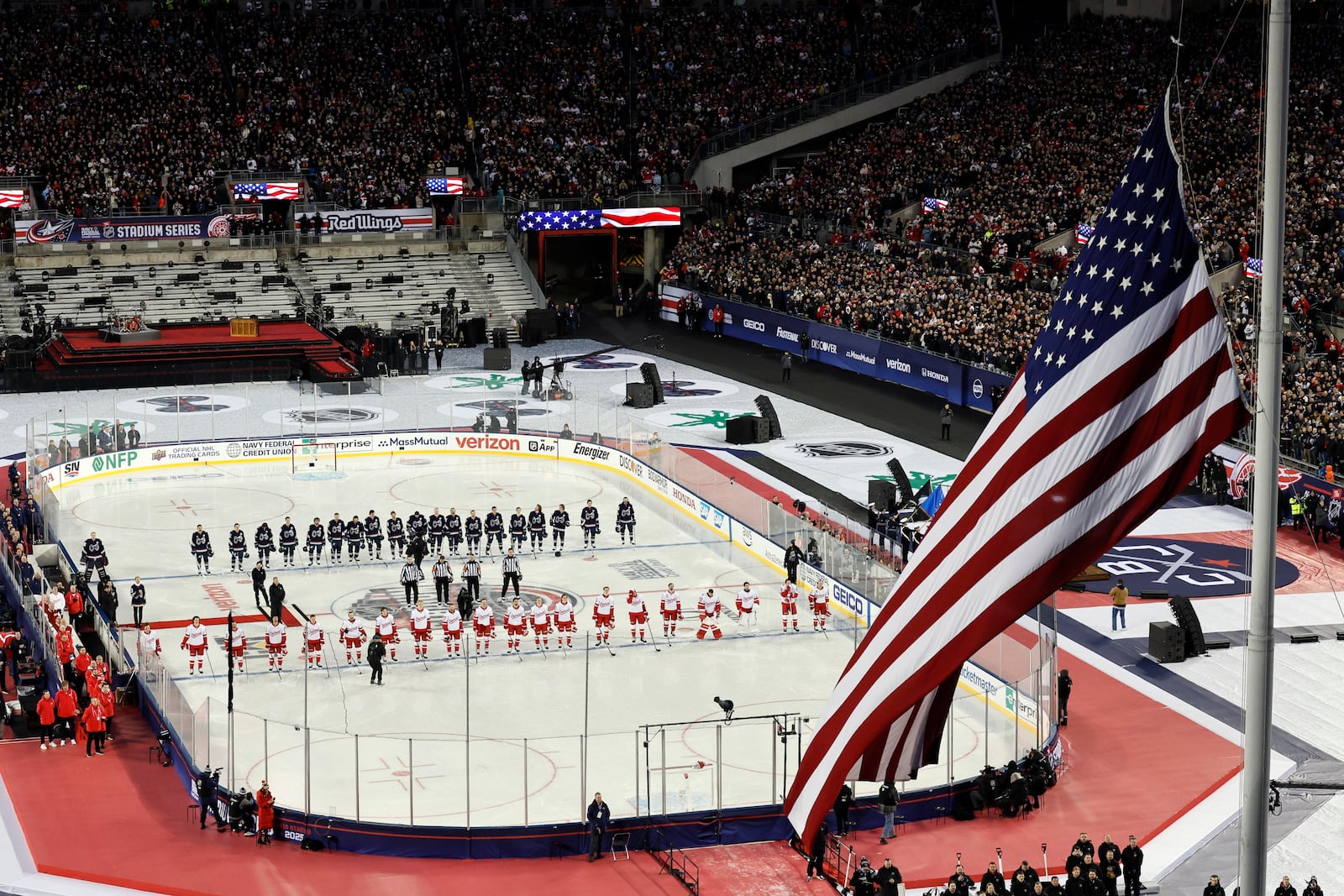 The Detroit Red Wings and the Columbus Blue Jackets stand for the National Anthem before the start of the Stadium Series NHL hockey game at Ohio Stadium, Saturday, March 1, 2025, in Columbus, Ohio. (AP Photo/Jay LaPrete)