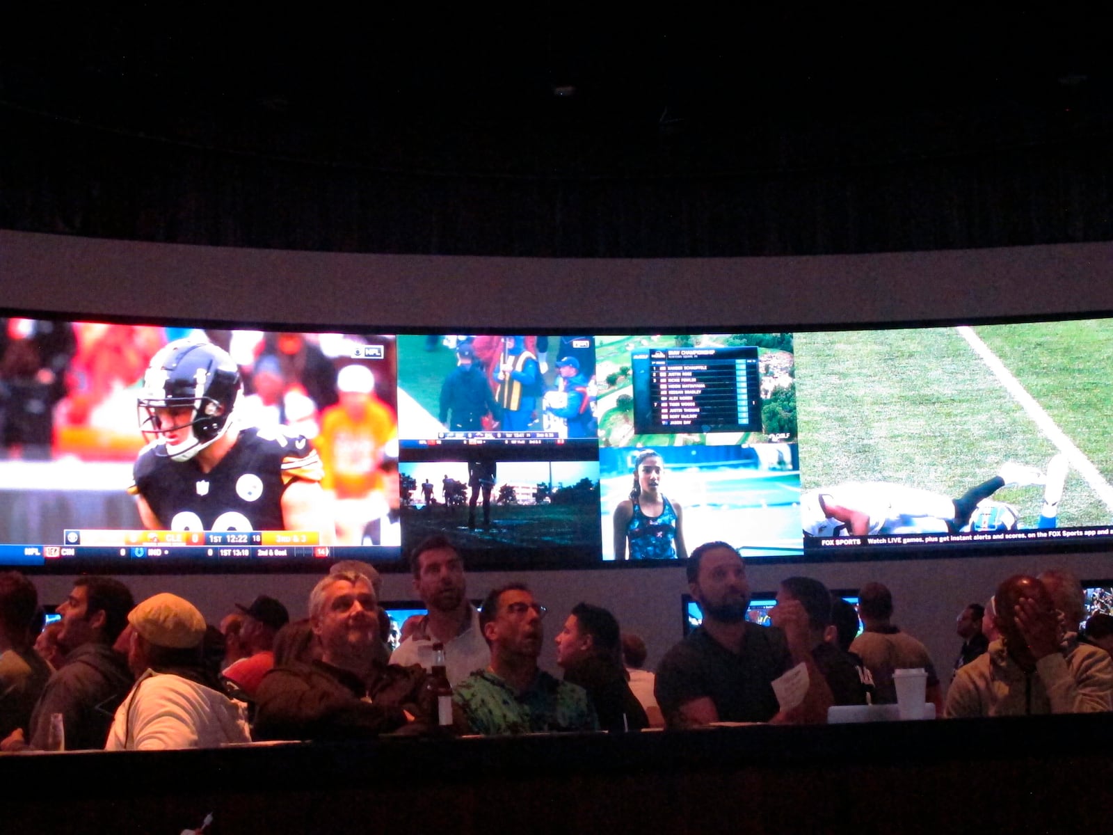 Football fans watch the action on wall-mounted video screens in the sports betting lounge at the Ocean Resort Casino in Atlantic City, N.J. on Sunday Sept. 9, 2018. The coronavirus virus outbreak has added new wrinkles for bettors this year,but even so, the nation's sports books expect a record year of bets on football in 2020 from an antsy public that has been cooped up for months amid the pandemic. (AP Photo/Wayne Parry)