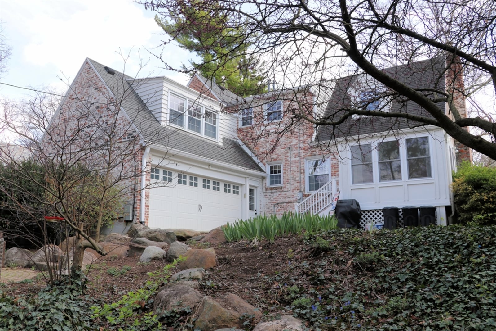 Large boulders accent stone steps to a circular patio and continue to the lower green space of the backyard.