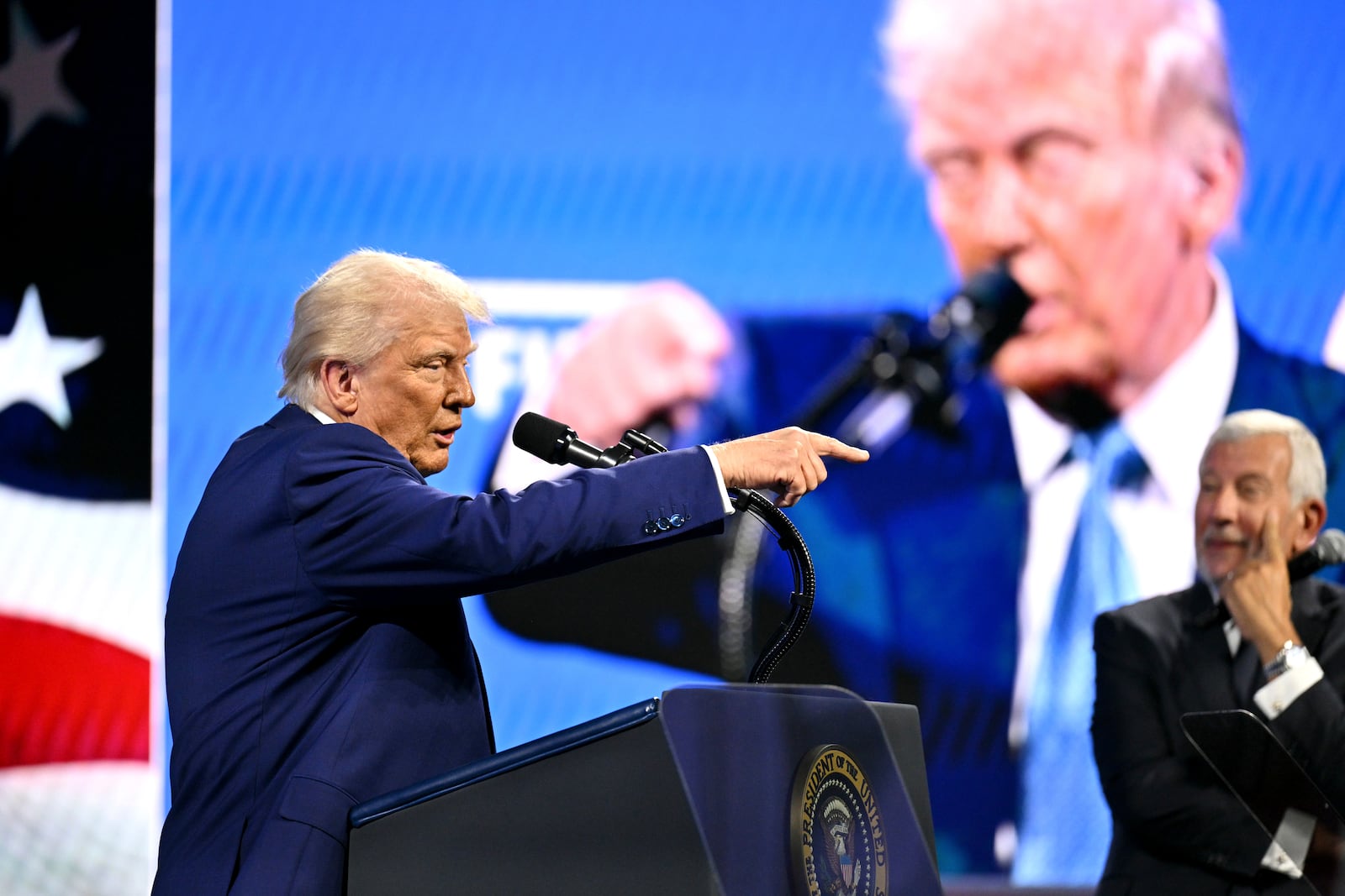 President Donald Trump speaks as chairman of the FII Institute Executive Committee Richard Attia listens at the Future Investment Initiative (FII) Institute summit in Miami Beach, Fla., Wednesday, Feb. 19, 2025. (Pool via AP)