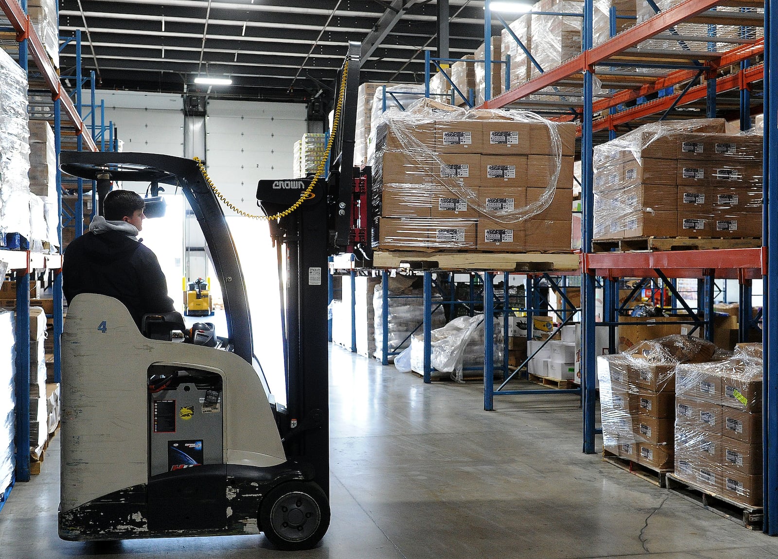 A food bank volunteer operates a forklift to collect food boxes. Foodbank, Inc. handles millions of pounds of food annually. MARSHALL GORBY\STAFF