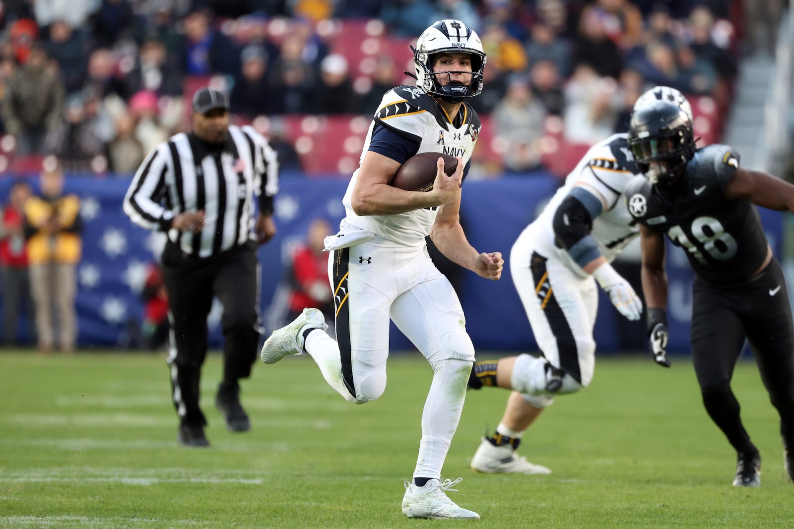 Navy quarterback Blake Horvath, center, runs with the ball for a gain during the first half of an NCAA college football game against Army, Saturday, Dec. 14, 2024, in Landover, Md. (AP Photo/Daniel Kucin Jr.)