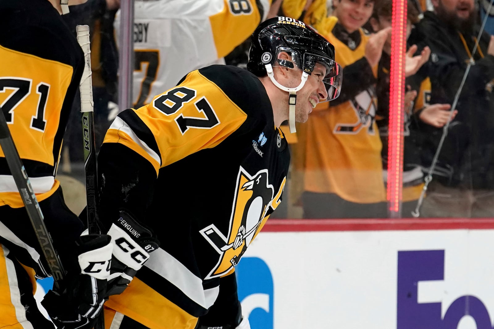 Pittsburgh Penguins' Sidney Crosby (87) celebrates after surpassing Mario Lemieux for the team's all-time leader in assists on a goal by Michael Bunting during the second period of an NHL hockey game against the New York Islanders, Sunday, Dec. 29, 2024, in Pittsburgh. (AP Photo/Matt Freed)