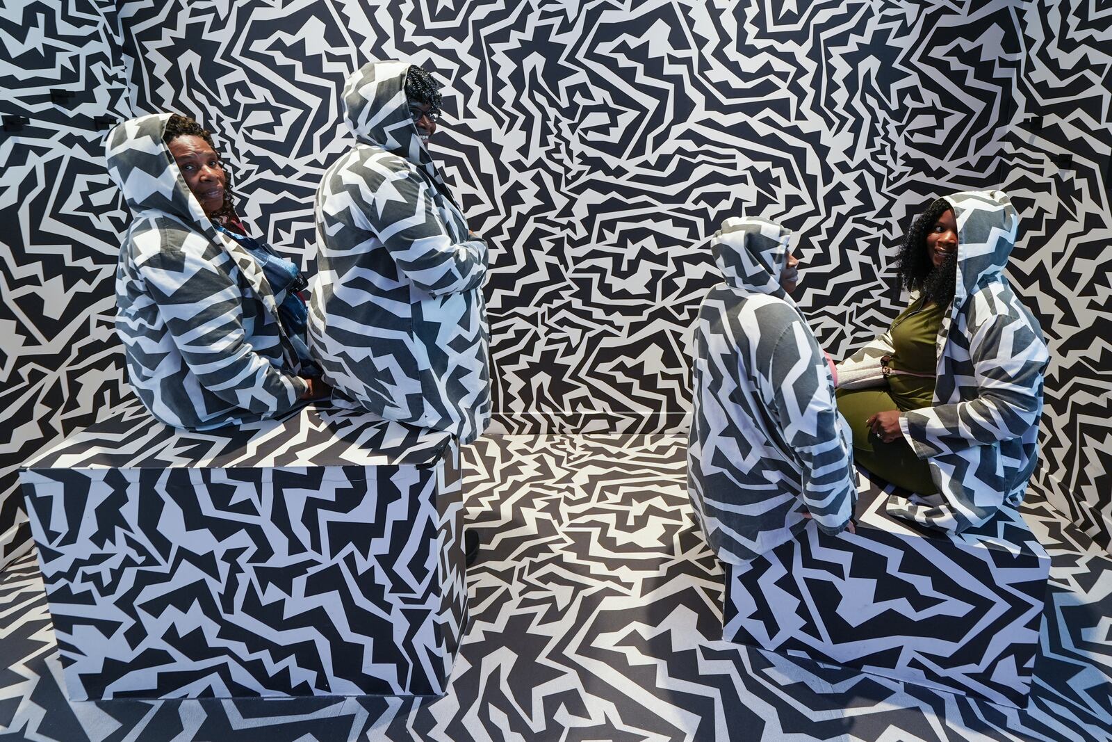 Members of the Miller family from Memphis, Tenn. pose inside an installation as they visit Paradox Museum Miami during a family trip celebrating the 50th birthday of Cassandra Miller, right, Tuesday, Jan. 28, 2025, in Miami. (AP Photo/Rebecca Blackwell)