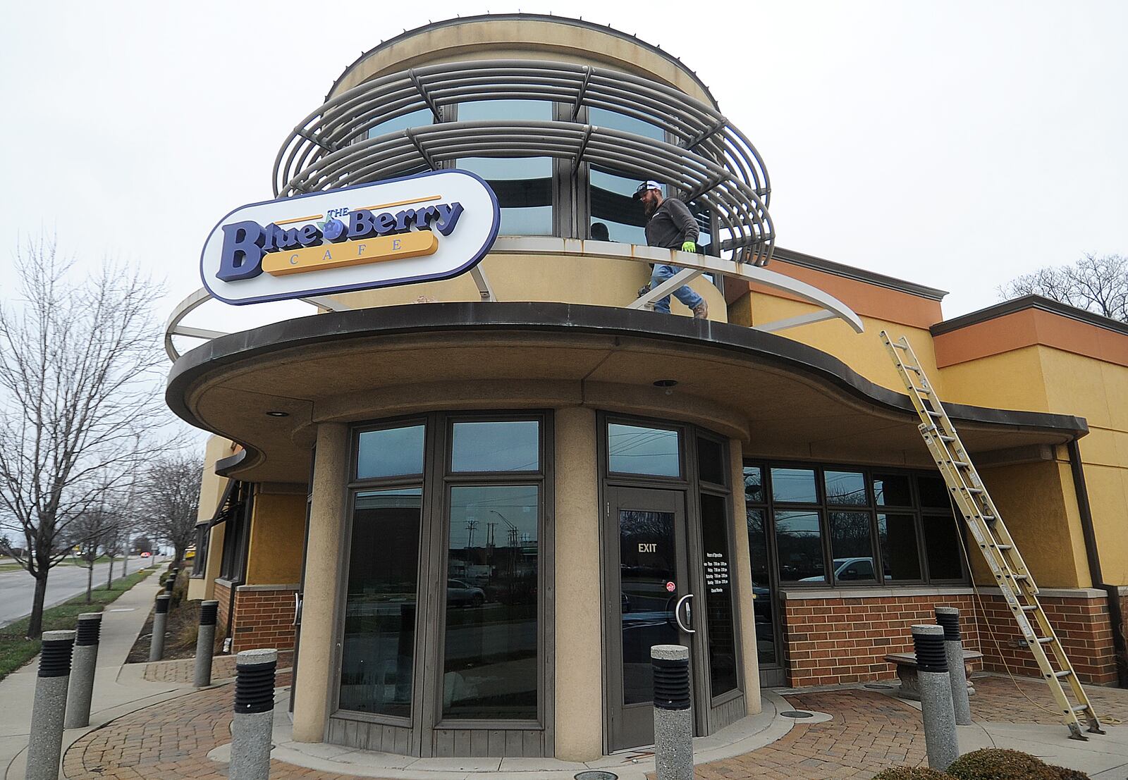 Marc Robinson of Wilcon Construction places The Blue Berry Cafe sign on the old Golden Nuggent Pancake House in Kettering Wednesday, Jan. 3, 2024. MARSHALL GORBY\STAFF