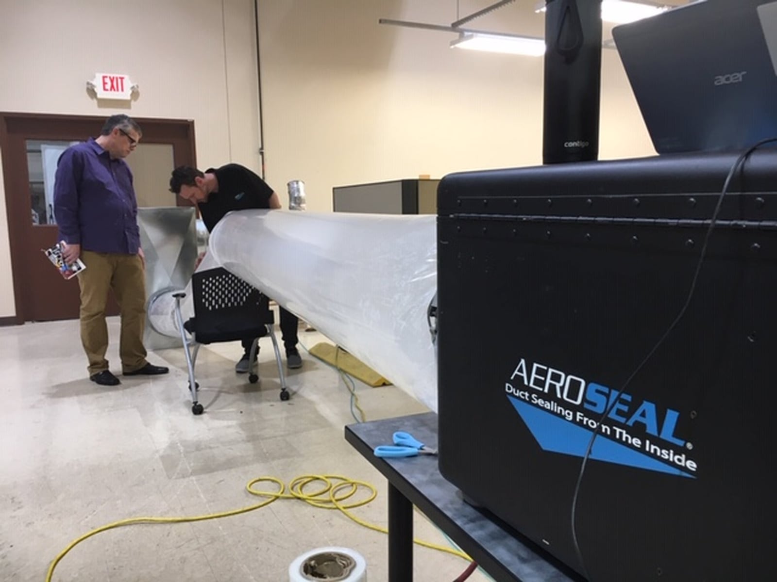 From left, Kevin Dugan, marketing director for Miamisburg company Aeroseal, and Matt Damron, Aeroseal strategic account manager, run a test in the duct-sealing technology company’s demonstration area. THOMAS GNAU/STAFF