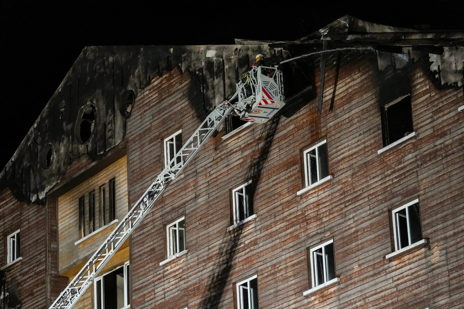 Firefighters work on the aftermath of a fire that broke out at a hotel in the ski resort of Kartalkaya, located in Bolu province, northwest Turkey, on Tuesday, Jan. 21, 2025. (AP Photo/Francisco Seco)