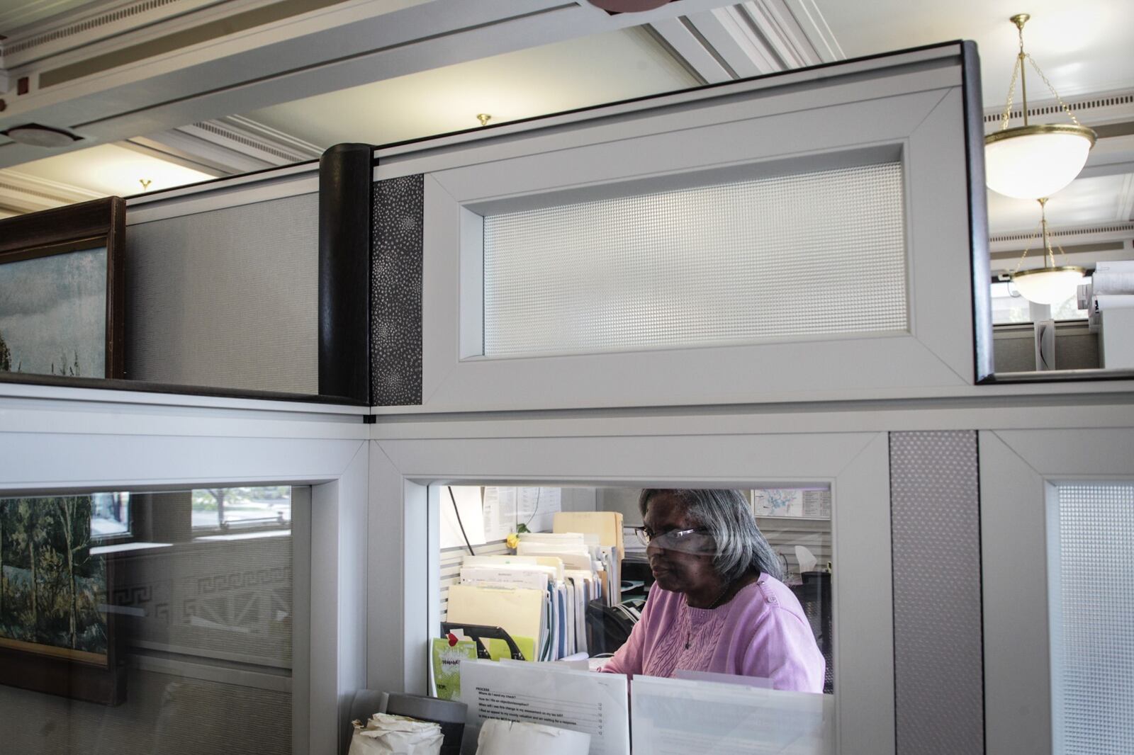 Roxanne Farrier, property administrator for the Miami Conservancy District, works in an enclosed cubical at the office on Monument Ave. The district adopted a hybrid workplace during pandemic. JIM NOELKER/STAFF