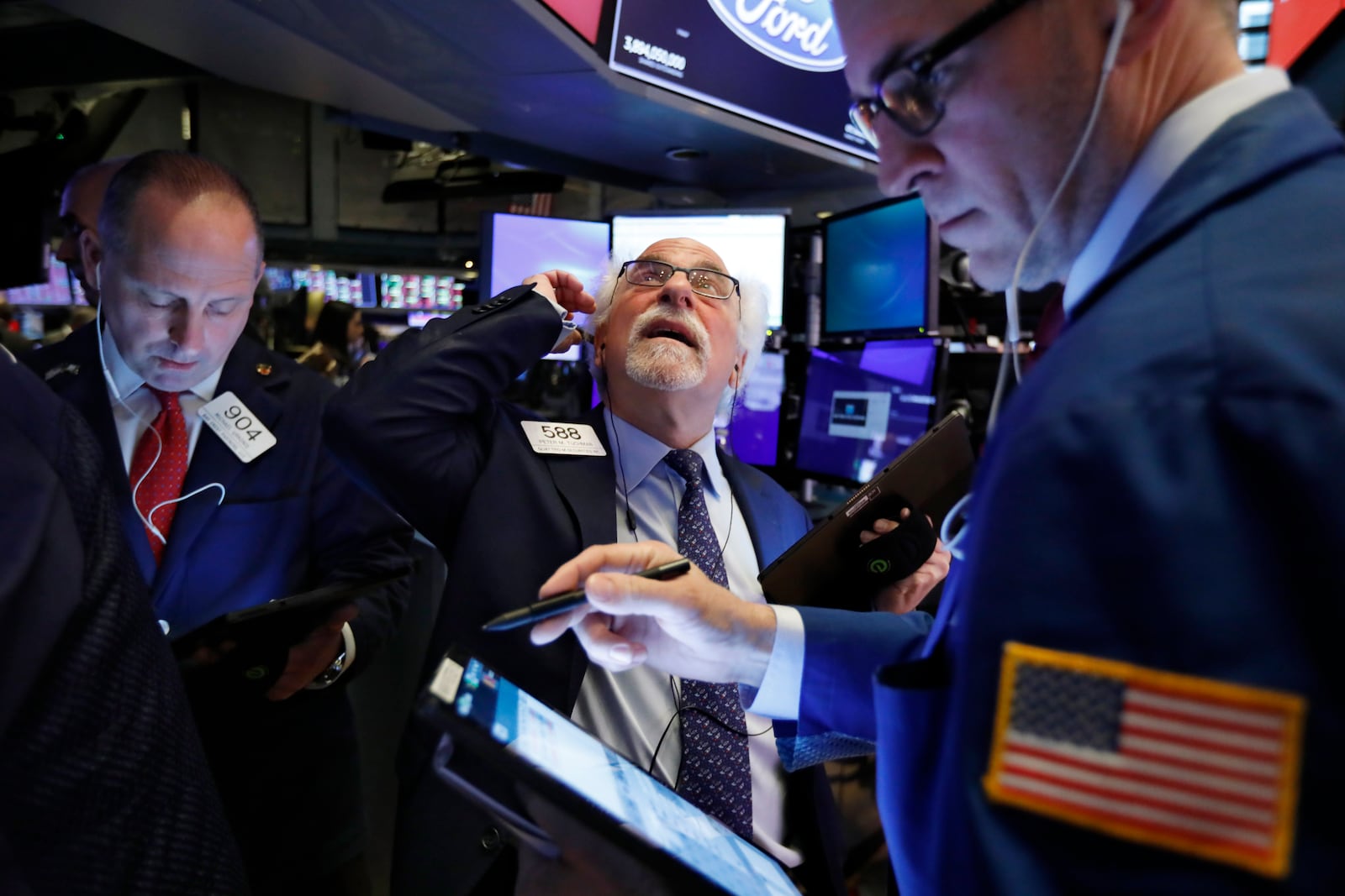 Traders Michael Urkonis, left, and Peter Tuchman, center, work on the floor of the New York Stock Exchange, Monday, Feb. 24, 2020. Stocks are opening sharply lower on Wall Street, pushing the Dow Jones Industrial Average down more than 700 points, as virus cases spread beyond China, threatening to disrupt the global economy. (AP Photo/Richard Drew)